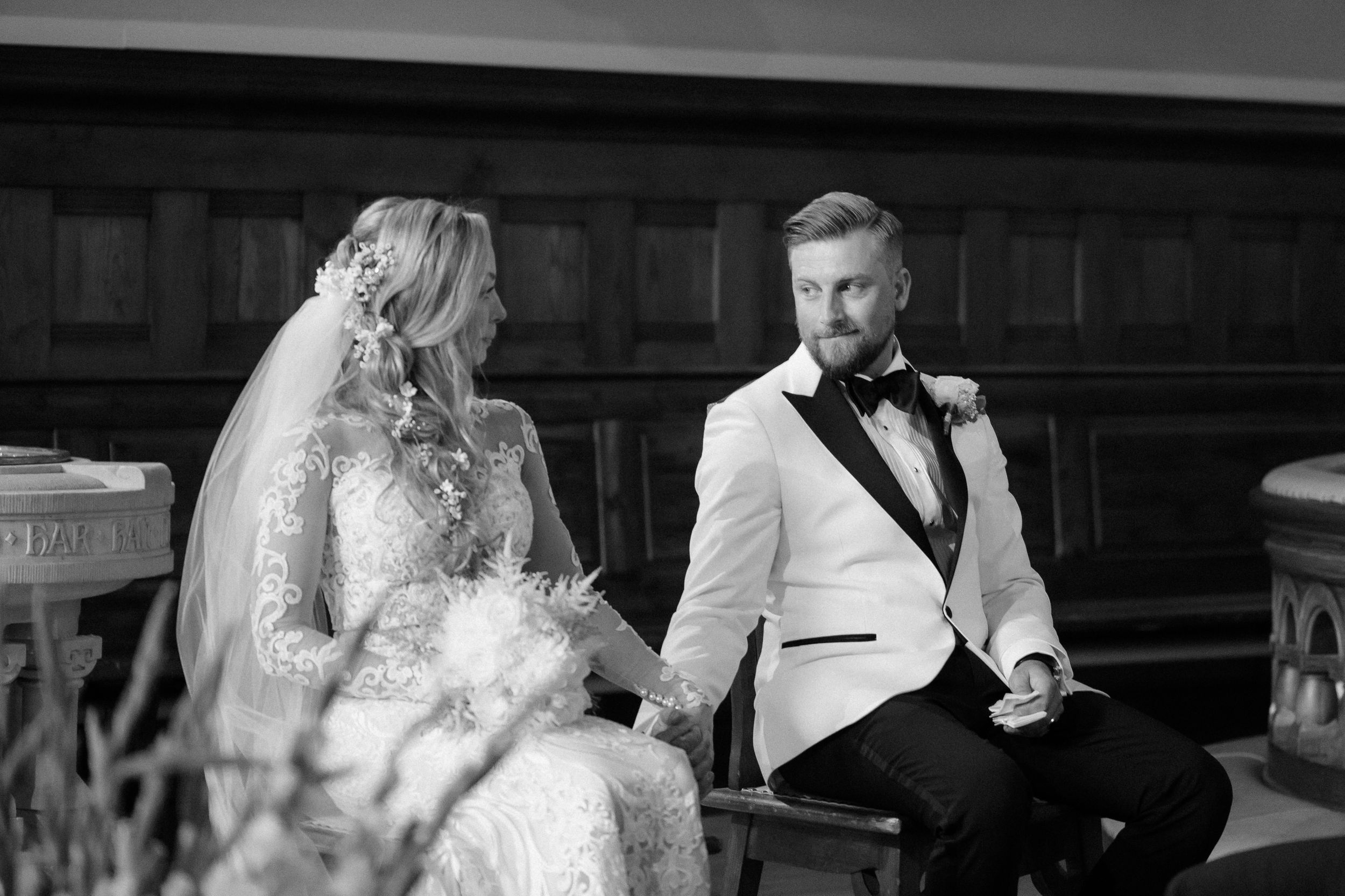 Black and white wedding ceremony photos showing interior of traditional church with elegant decor and lighting.