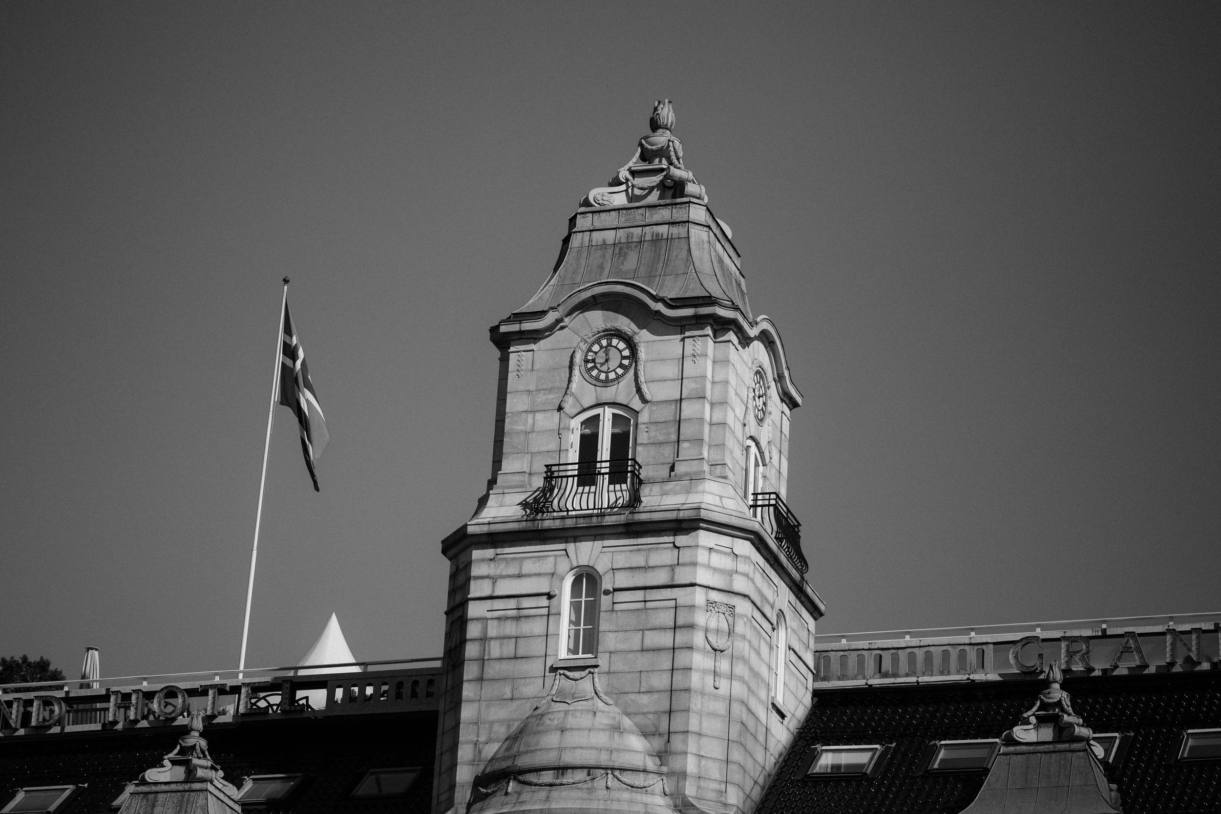 A black and white cityscape showing multiple church steeples and historic building tops against a dark sky.