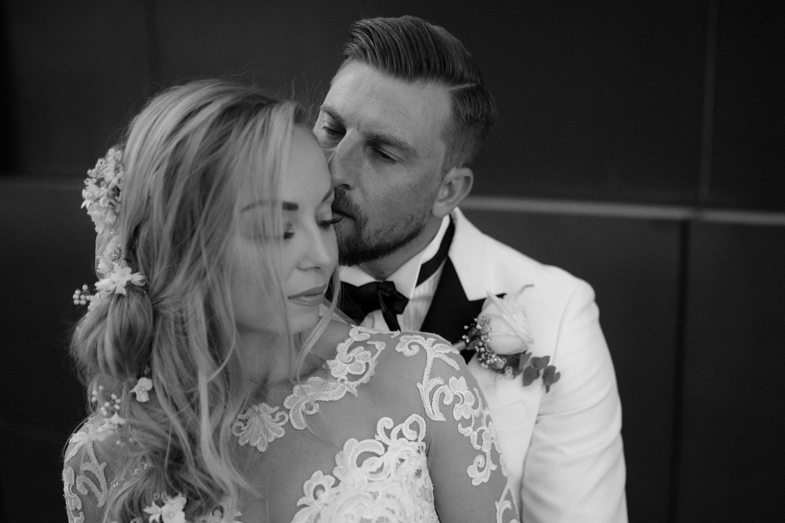 Romantic black and white portrait of newlyweds sharing an intimate moment.
