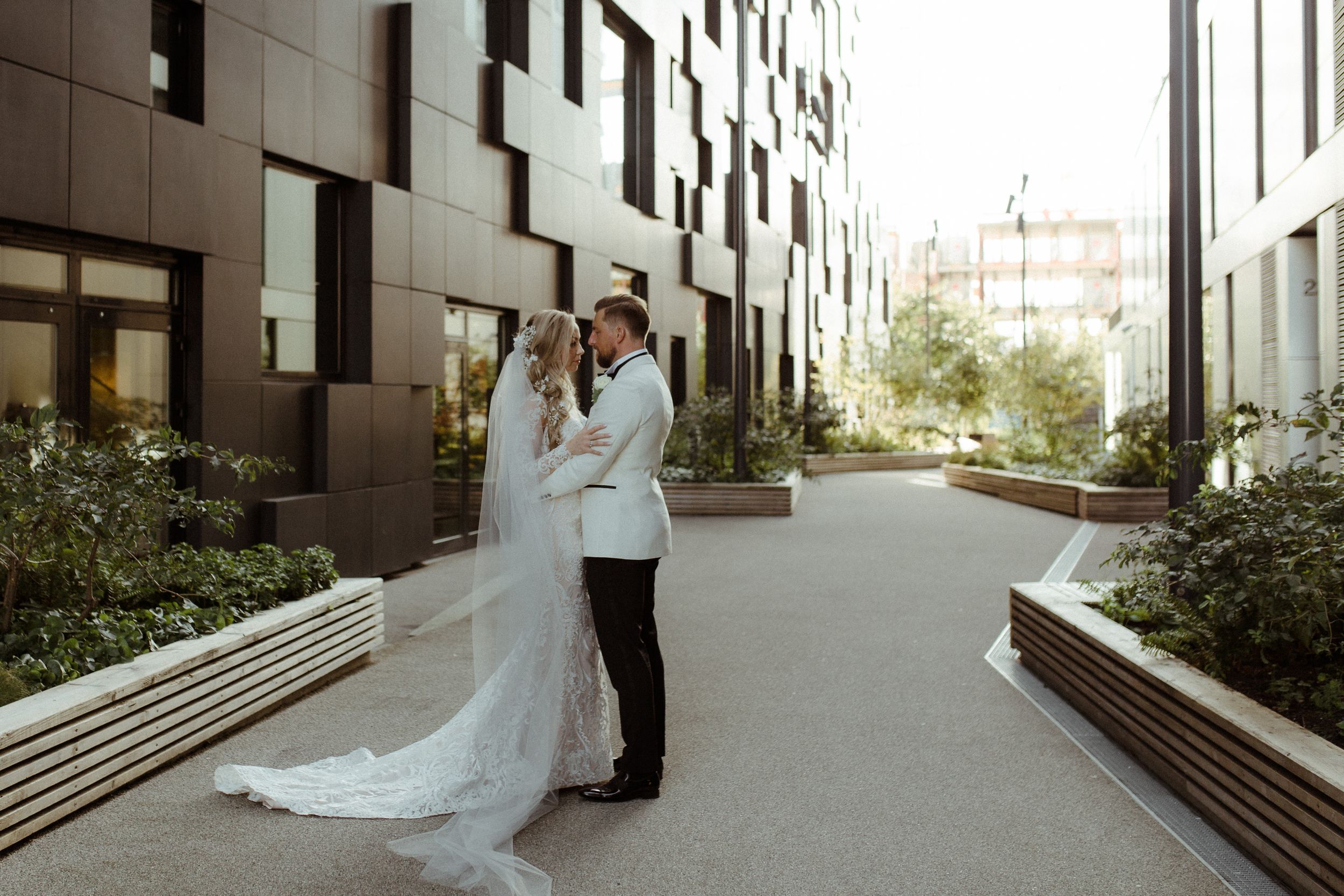 Modern architectural backdrop with white buildings creating a minimalist wedding scene.