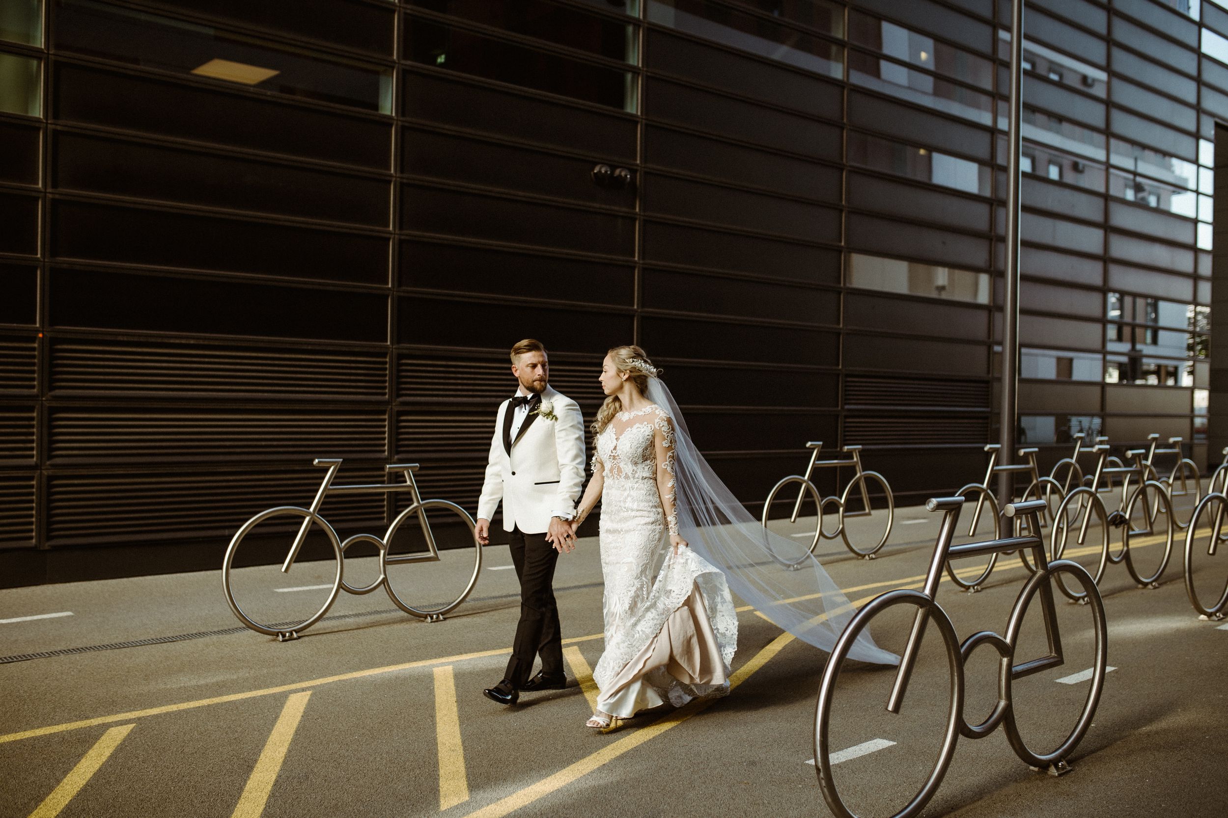 Modern architectural backdrop with row of vintage bicycles displayed against dark wall.