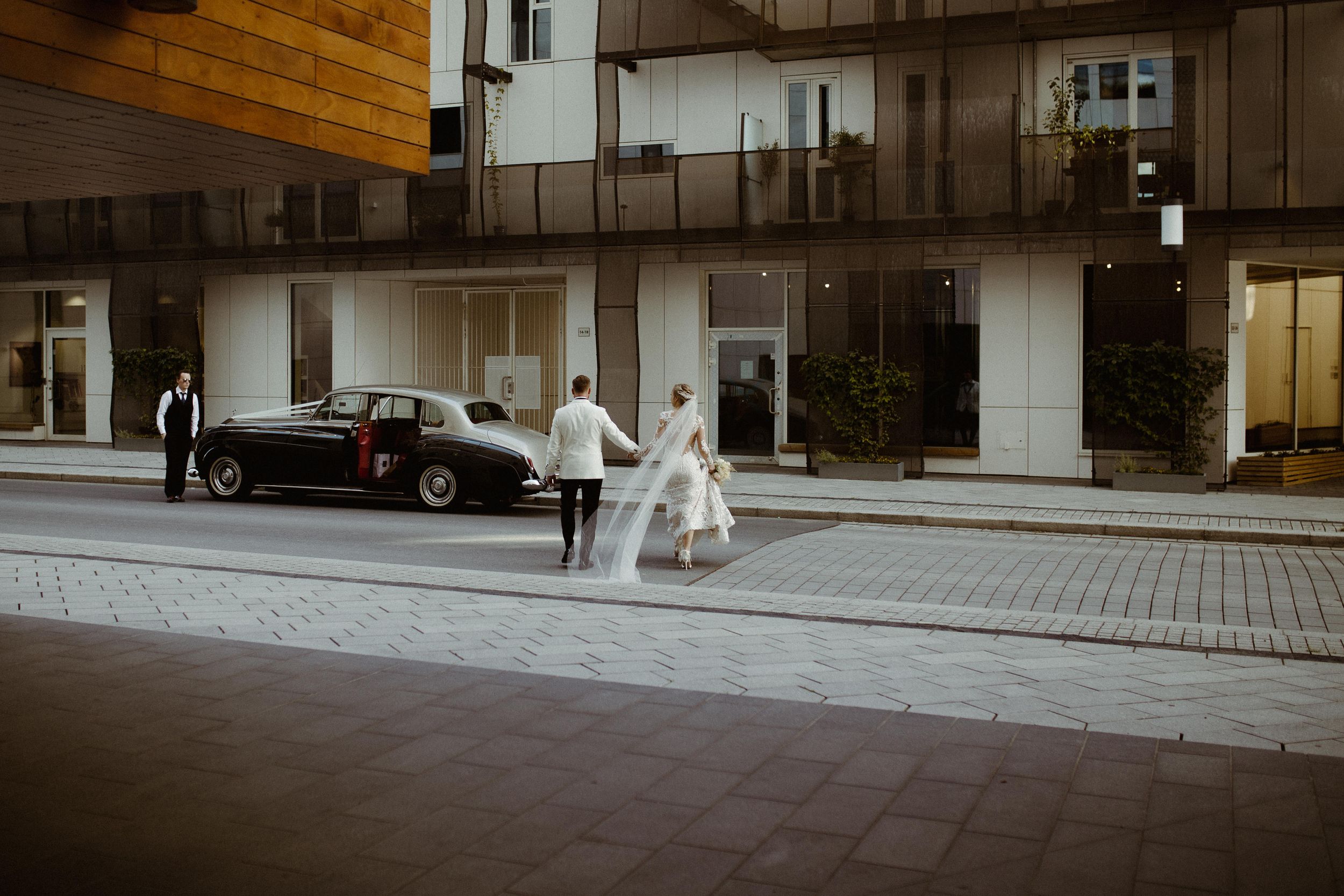 Modern building exterior with stone walkway and architectural details at dusk.