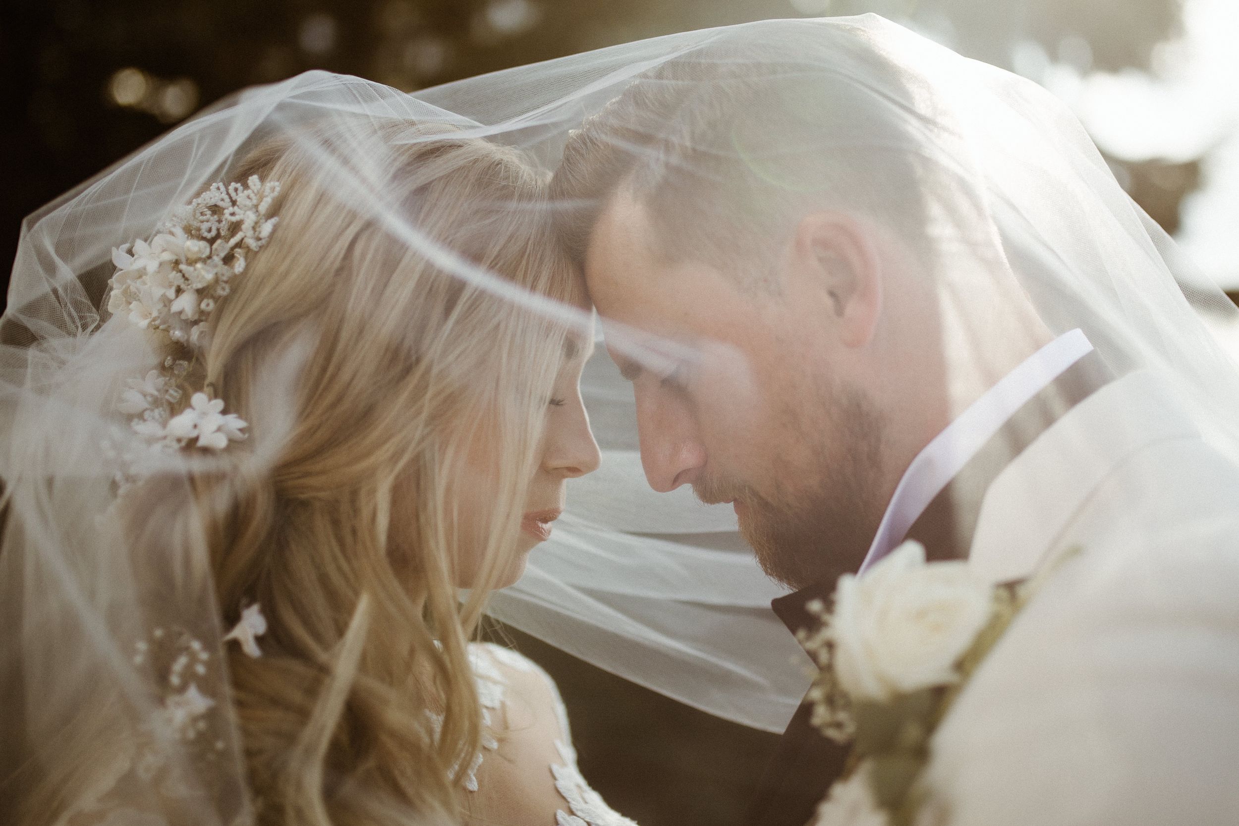 Delicate wedding veil flows in the breeze during an intimate moment.