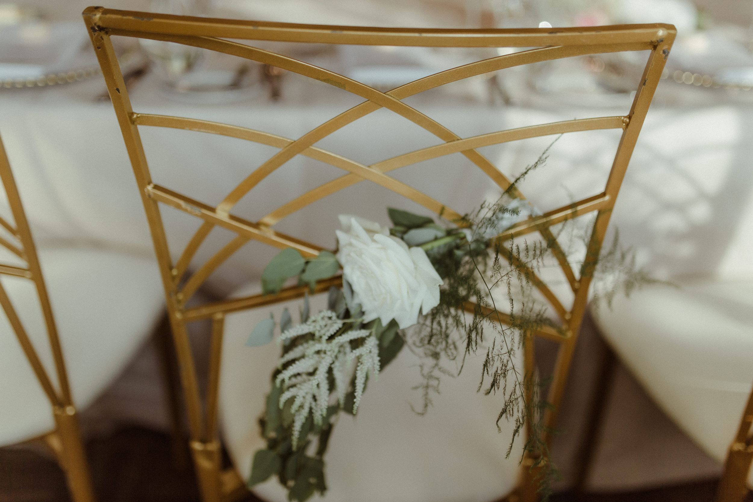 Gold geometric decor elements with white floral arrangements at an upscale event setting.