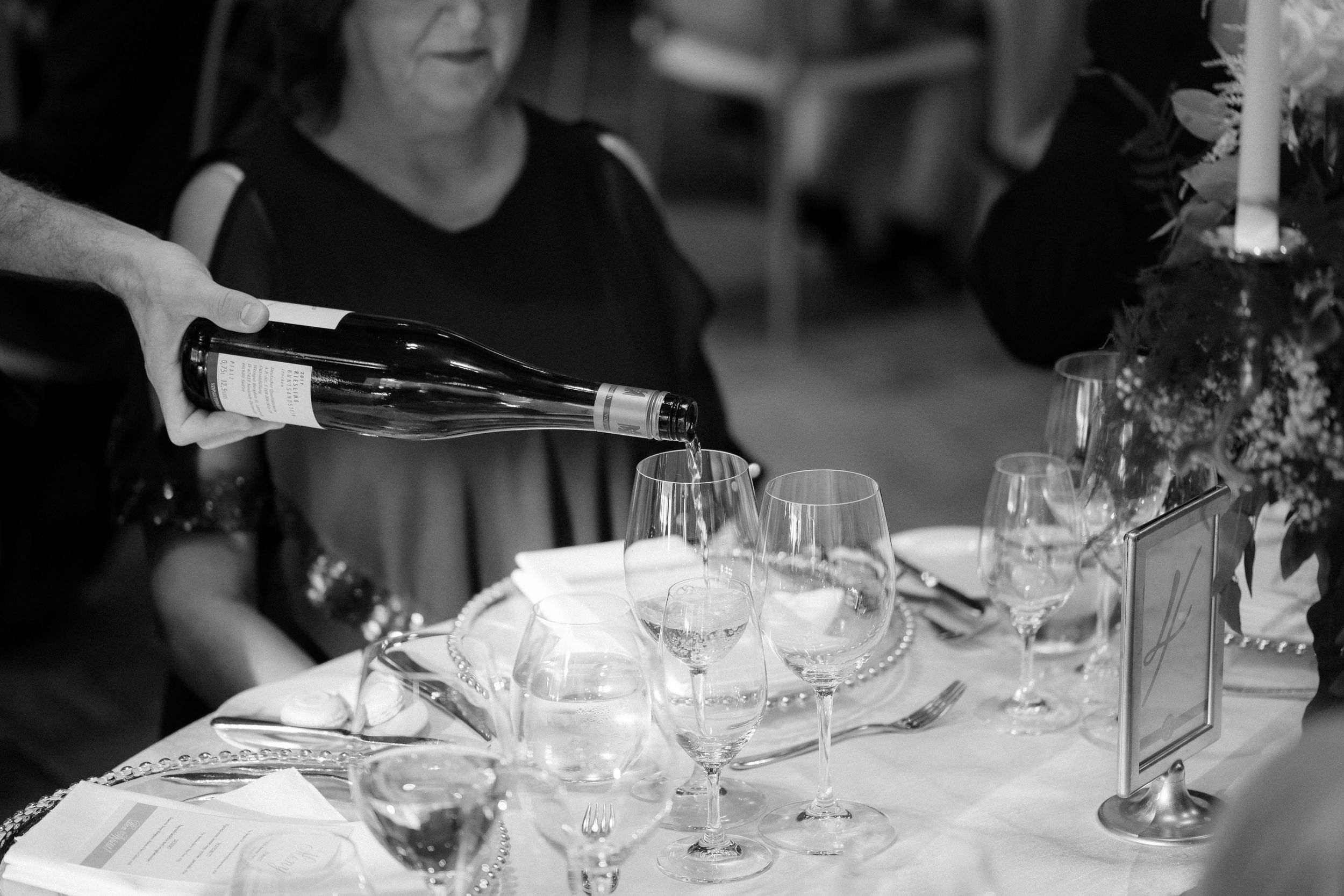 Elegant dining table setup at a wedding reception with sparkling glassware and white linens.