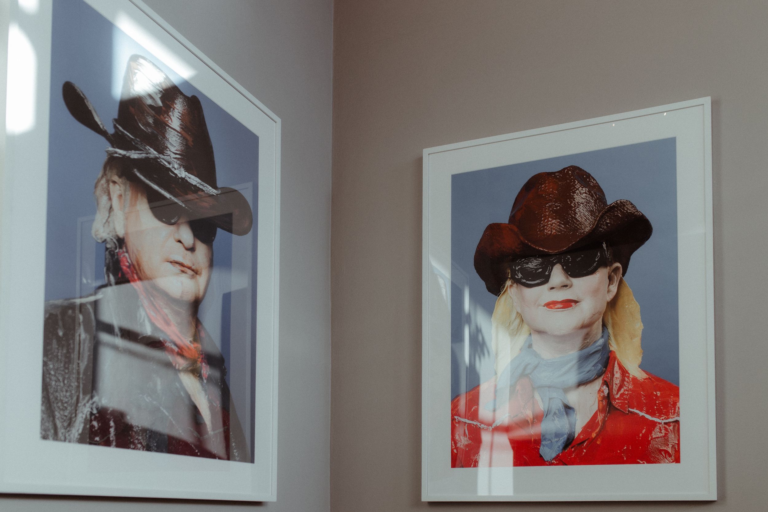 Gallery wall displaying artistic fashion photographs in white frames.