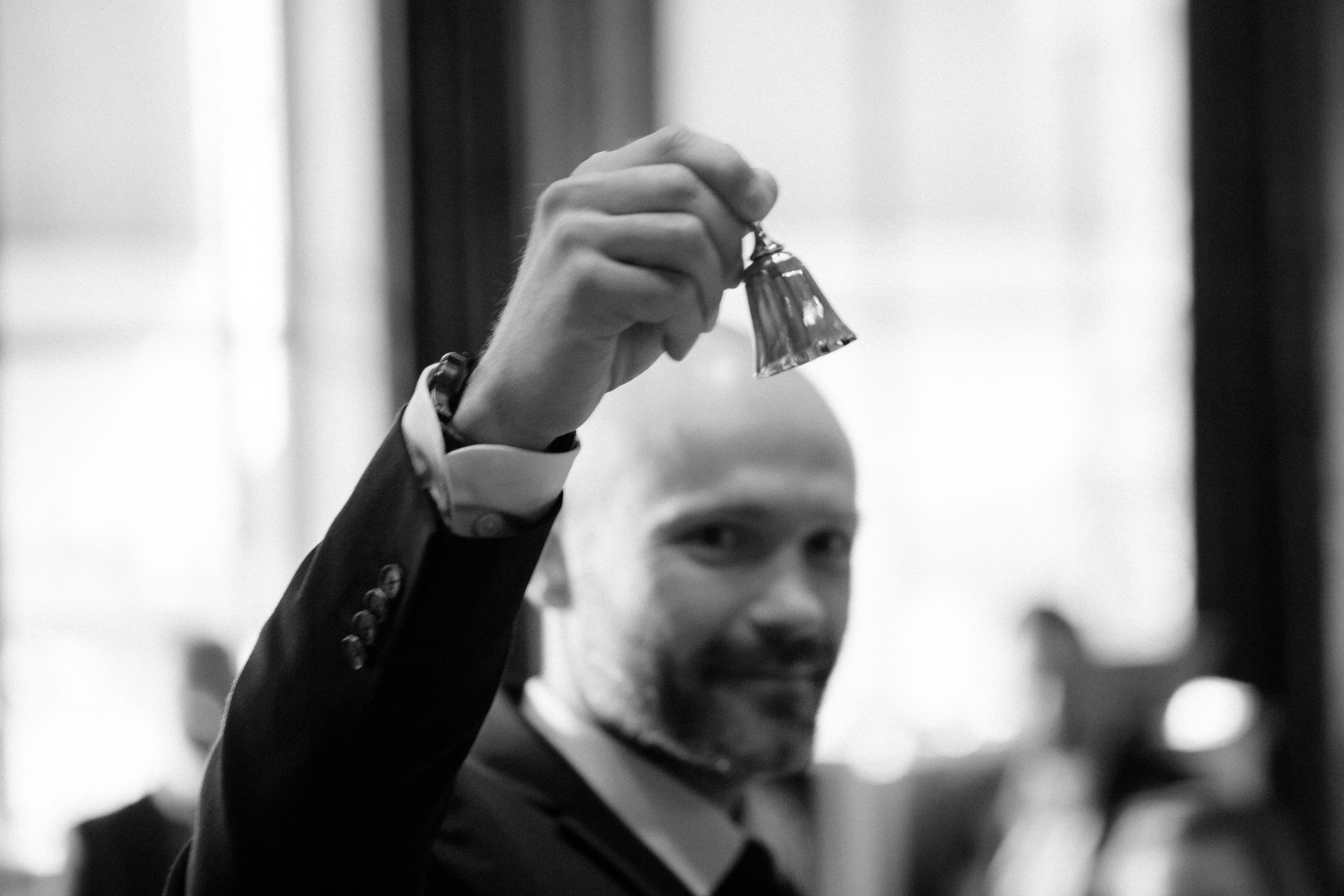 Black and white candid photo capturing lively moments at a formal event.