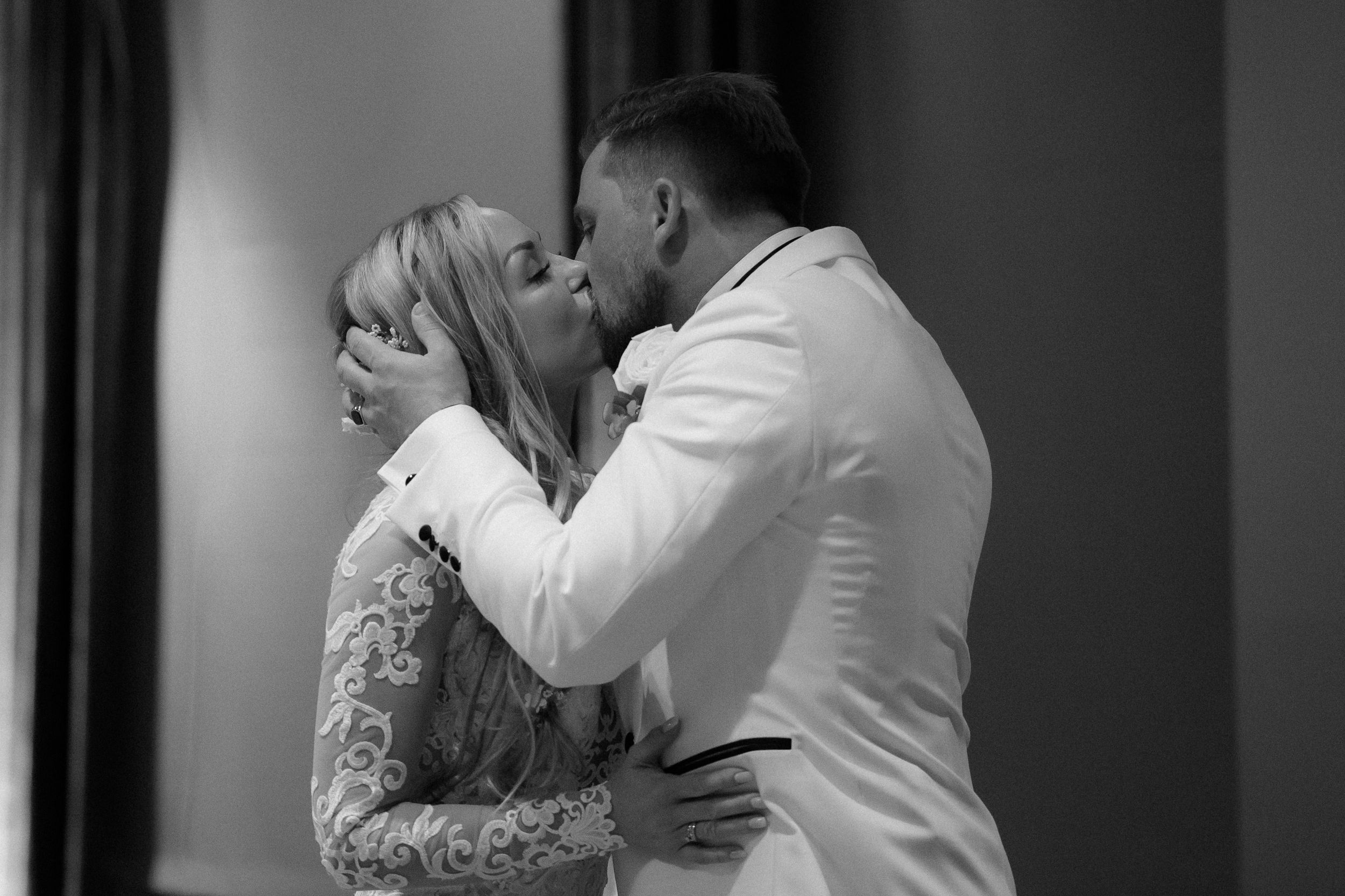 Black and white romantic moment captured during an elegant wedding celebration.
