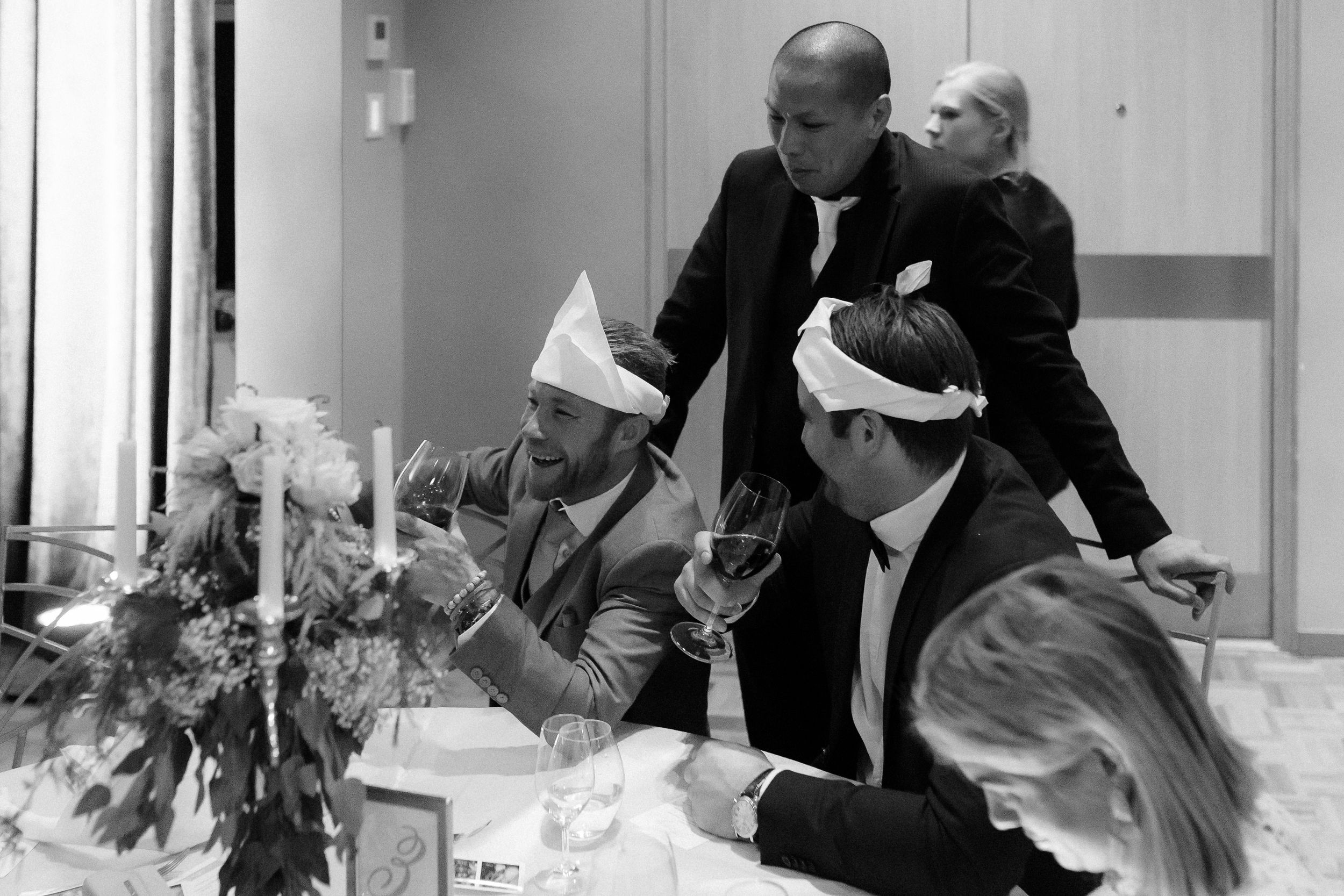 Wedding guests celebrating at a formal reception venue with elegant tablescapes and decor.