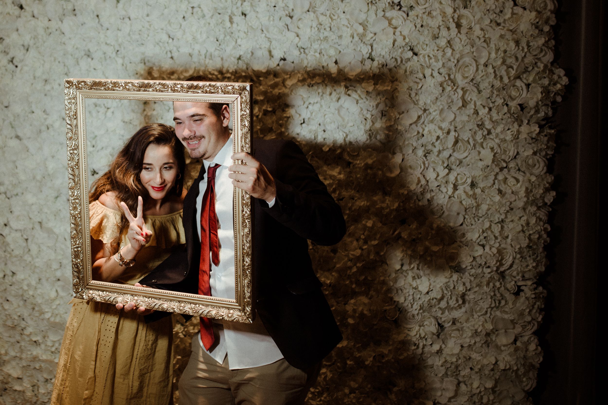 Vintage-style wedding photo against textured wall with dramatic shadows.