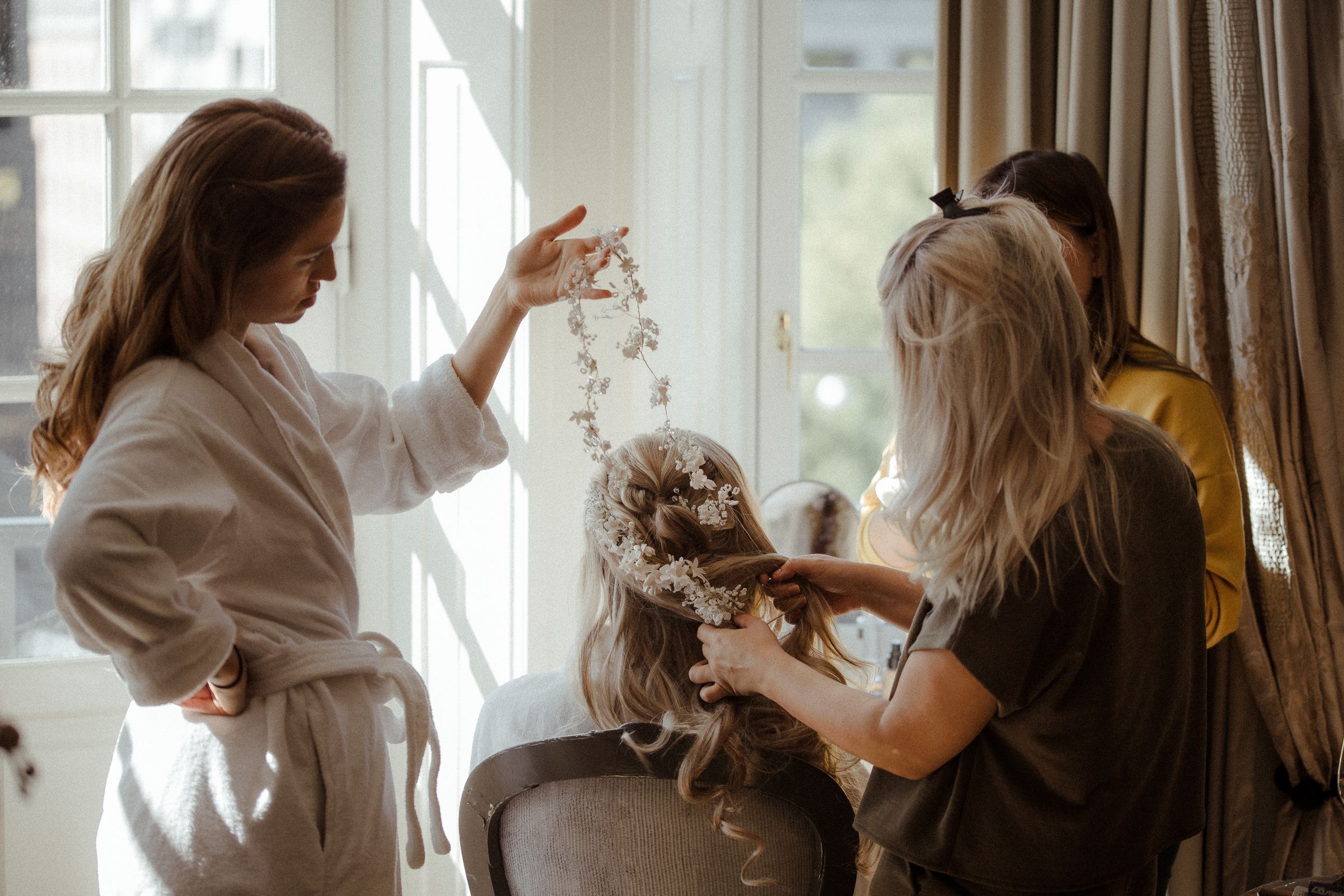 Wedding preparation scene with soft natural window lighting in elegant room.