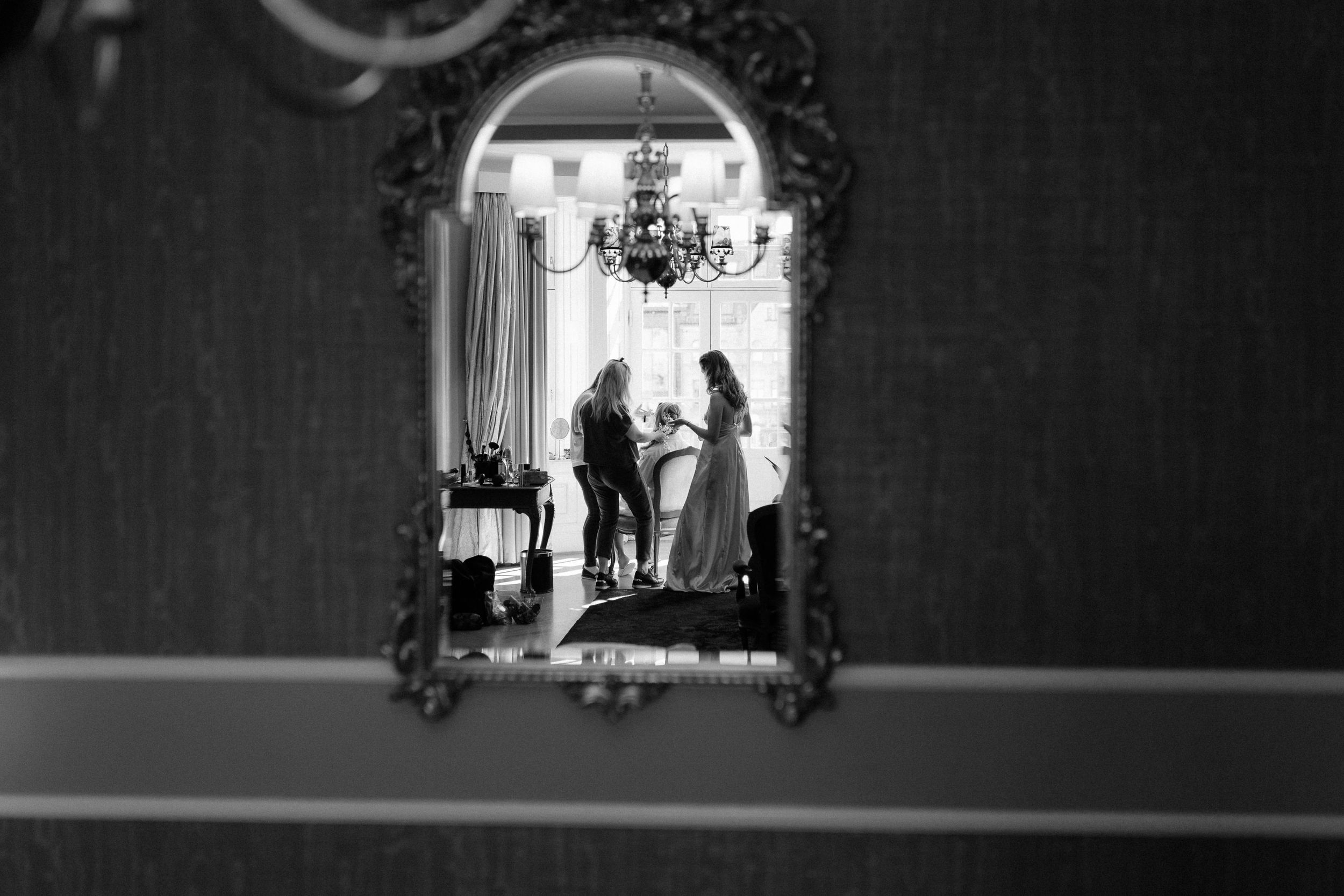 Silhouettes stand under ornate arch in dramatic black and white wedding scene.