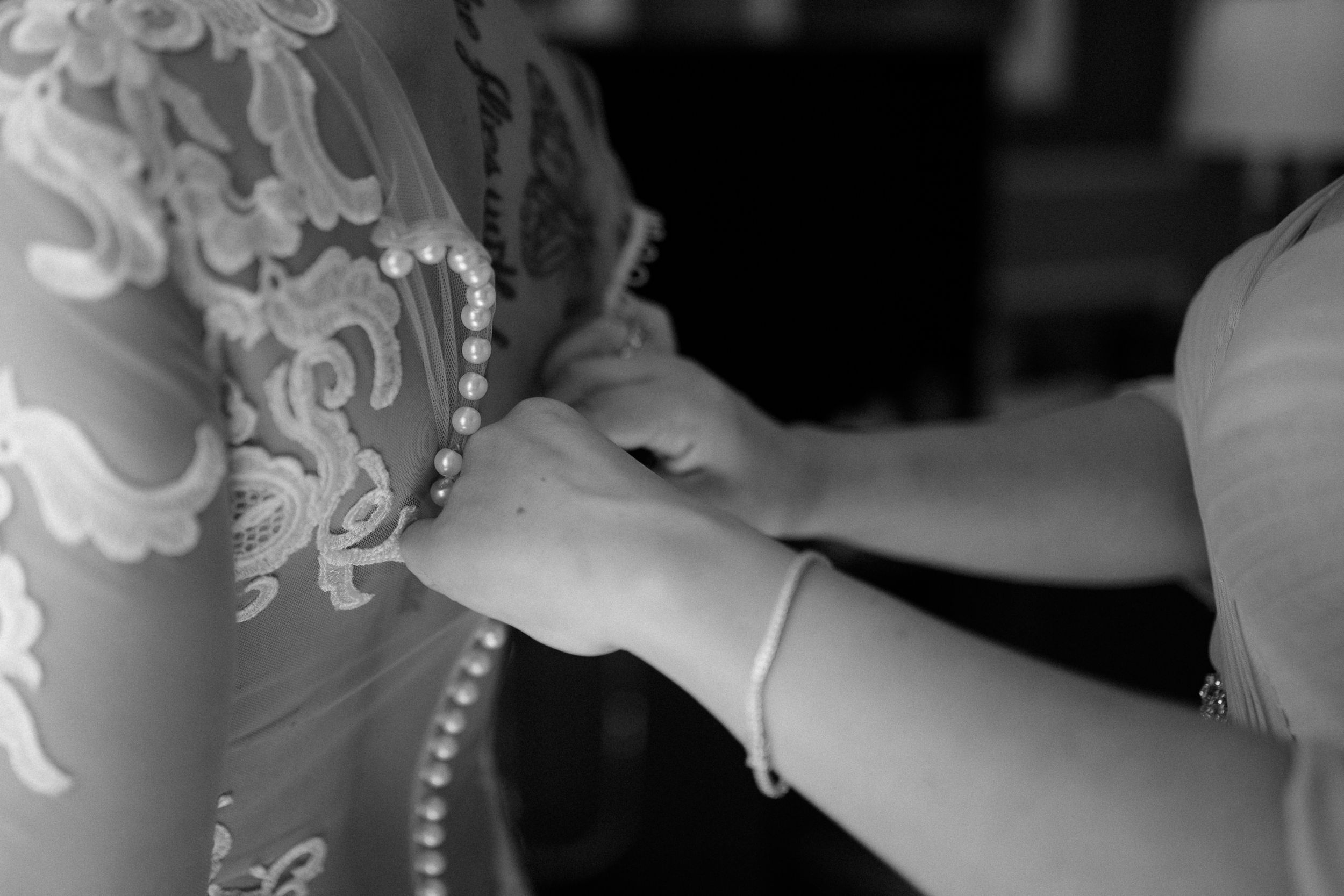 Close-up detail of intricate white lace and pearl embellishments.