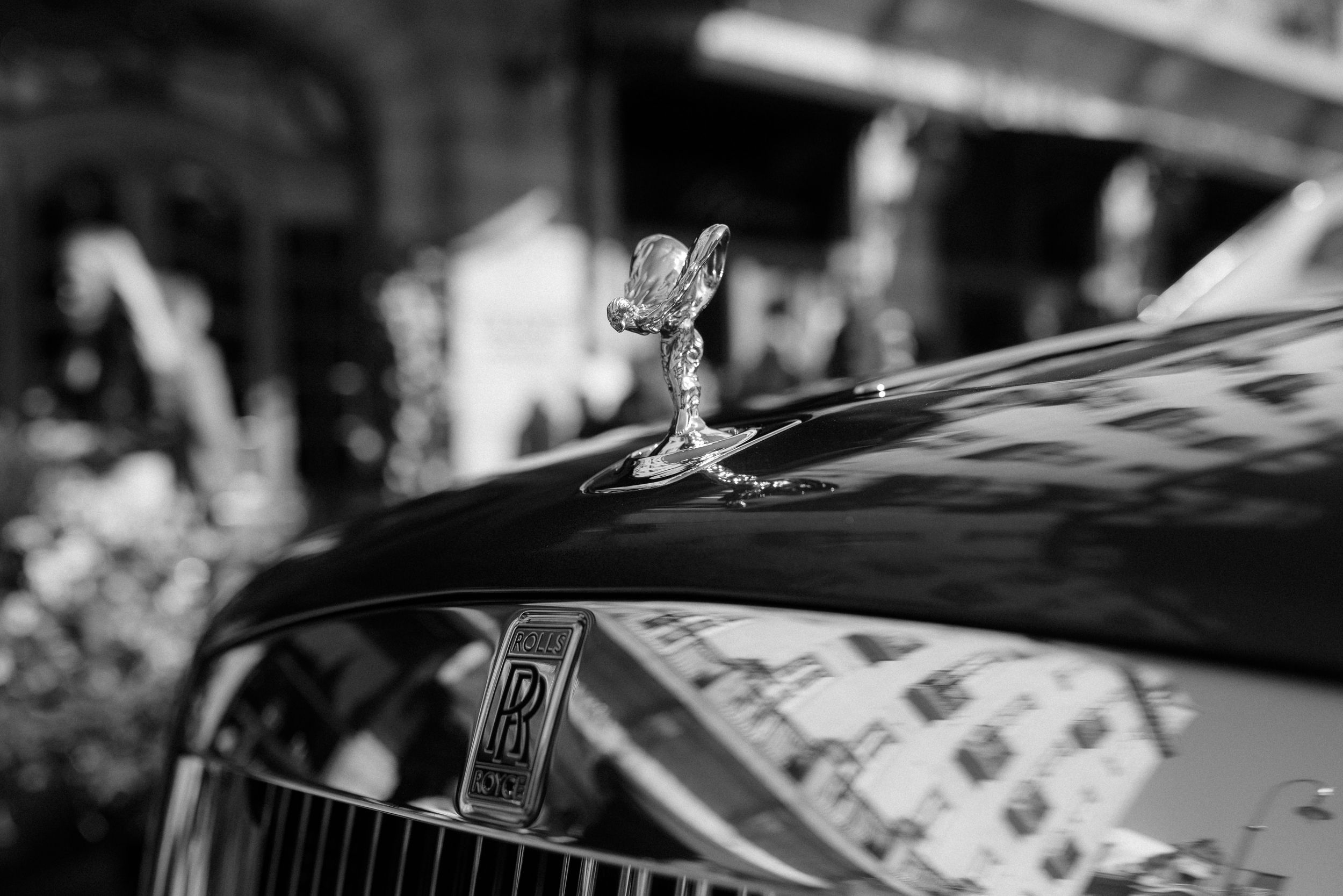 Close up of classic Rolls Royce hood ornament in black and white photography.