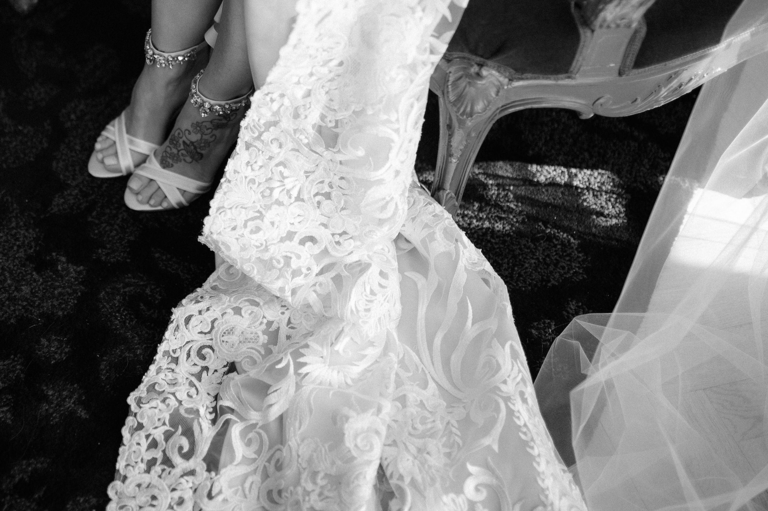 Flowing white bridal gown details showing intricate lace embellishments and fabric textures.