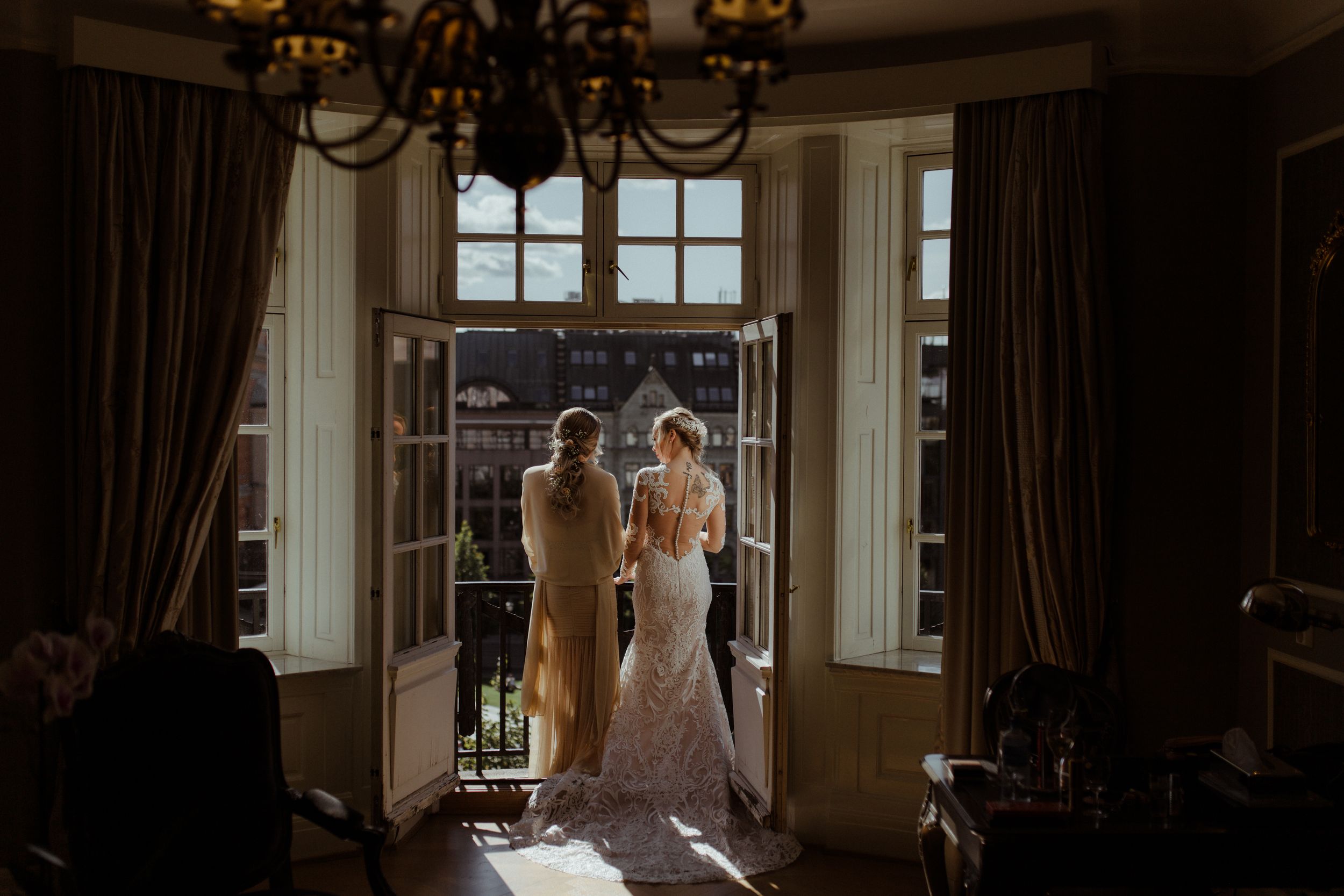 Elegant bridal preparation scene in a luxurious room with natural window light.