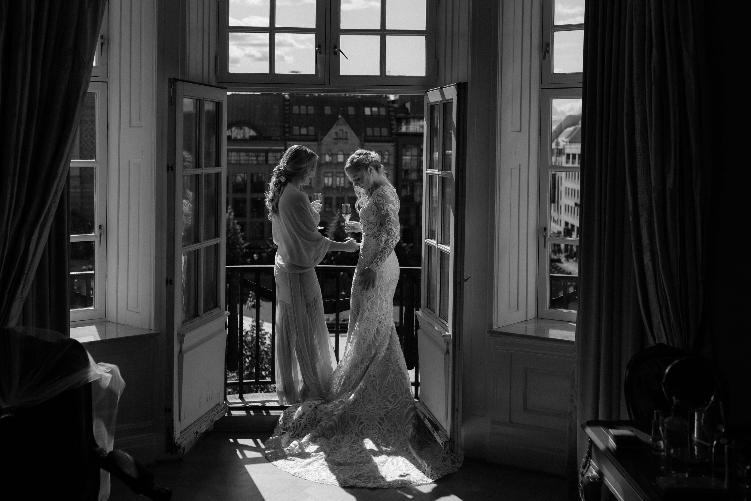 Black and white wedding photos showing elegant French windows and dark curtains.