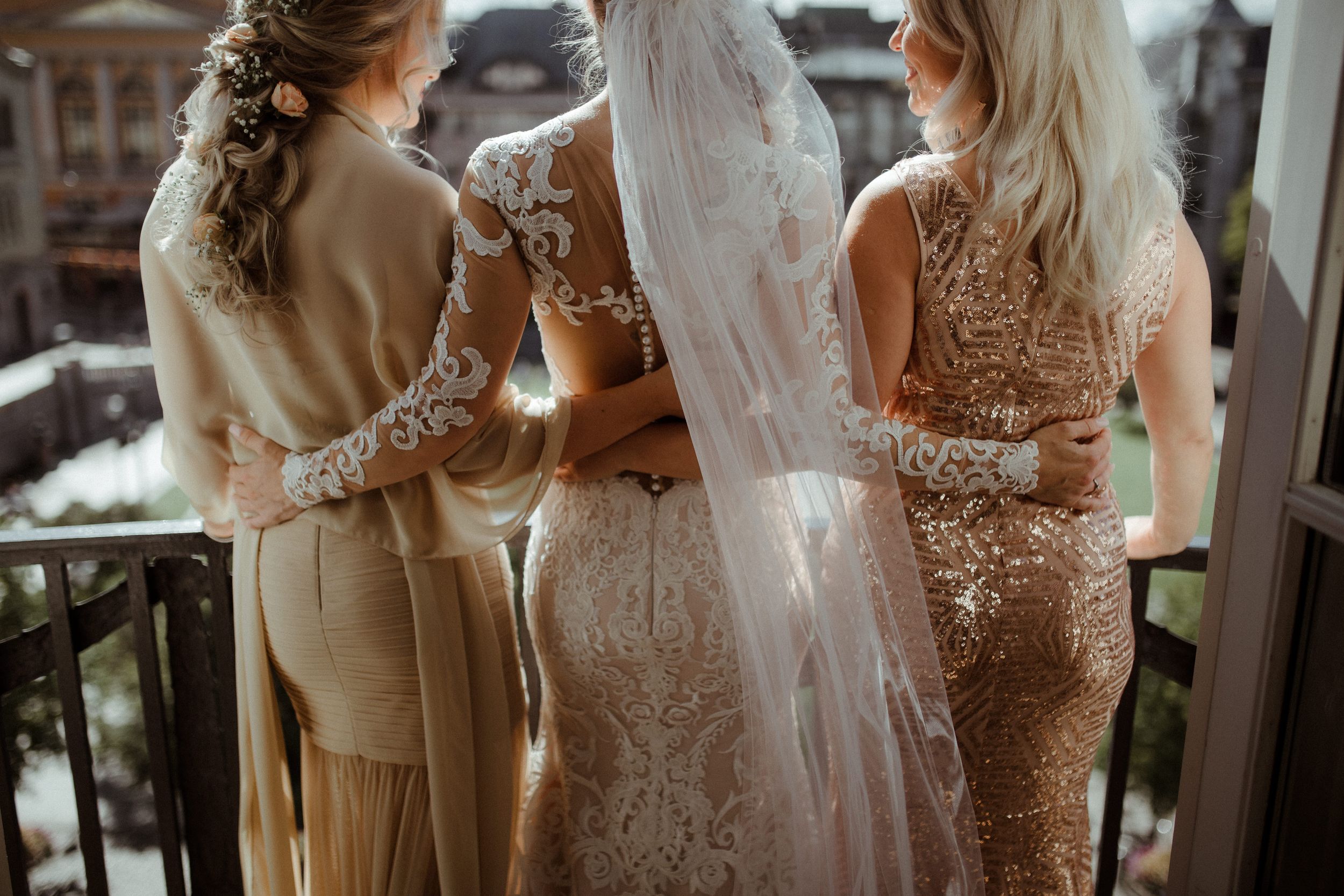 Close-up details of elegant lace wedding dresses lined up before ceremony.