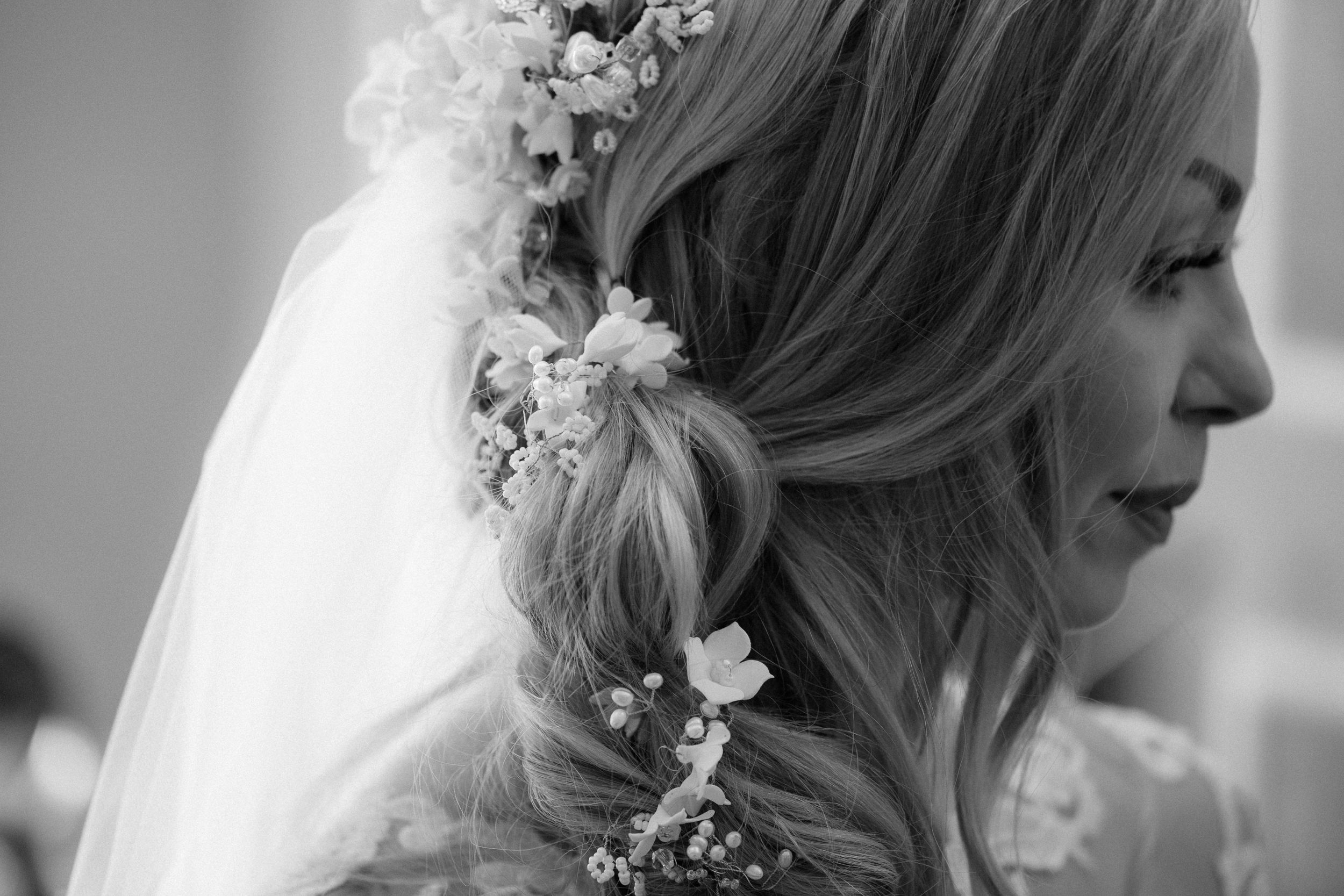 Wedding details showing delicate floral hair accessories and bridal styling in black and white.