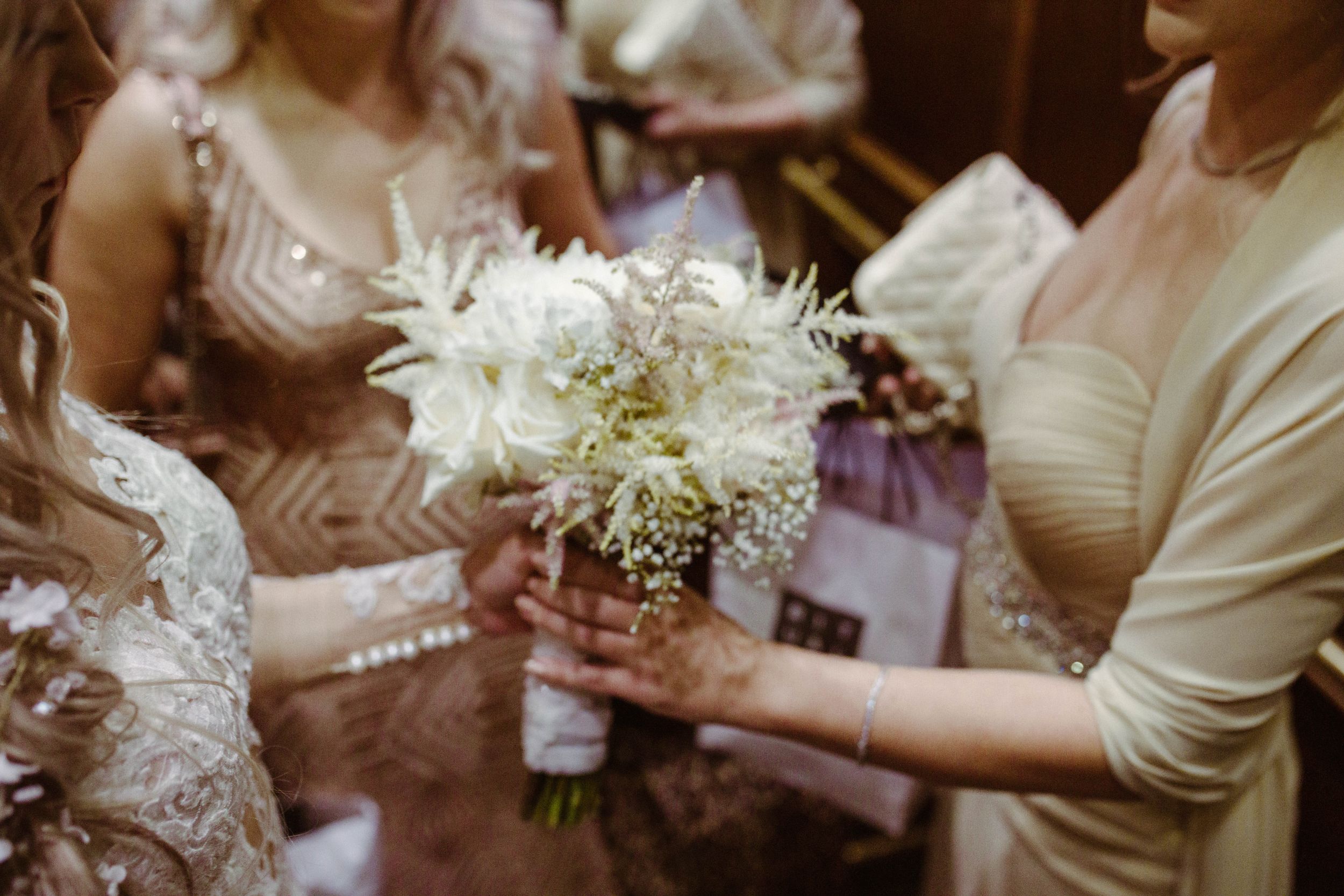 White wedding bouquet held with delicate flowers and baby's breath.