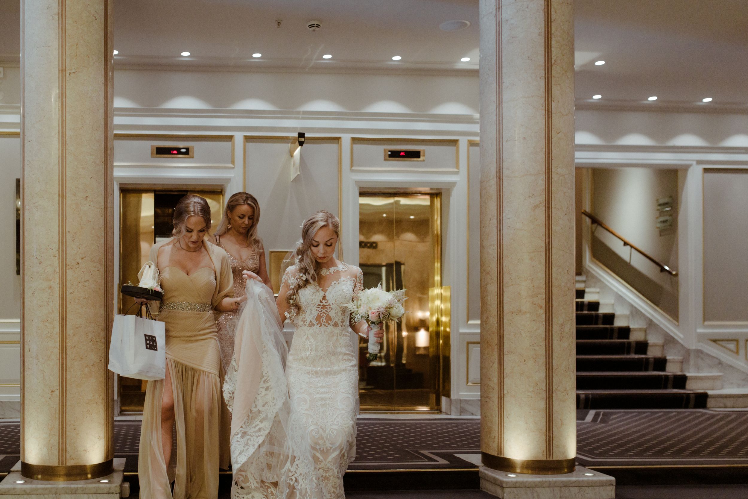An elegant wedding ceremony venue with white columns and decorative lighting illuminating the grand ballroom.