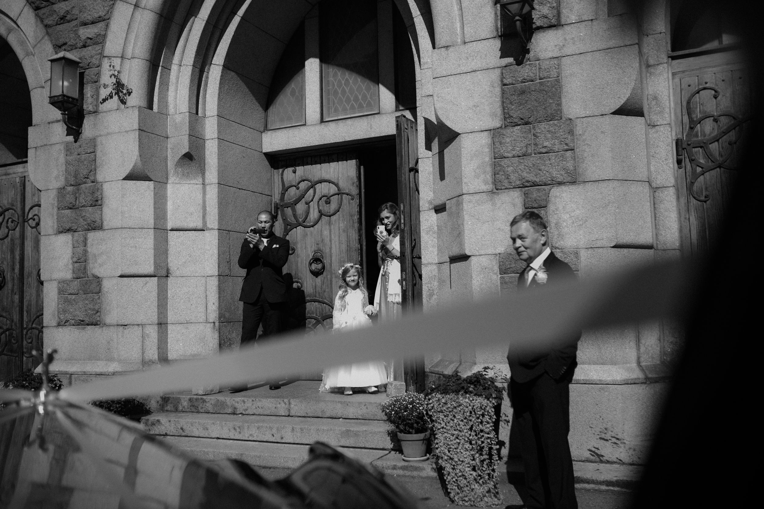 A classic black and white exterior shot of a stone building with arched architectural details.