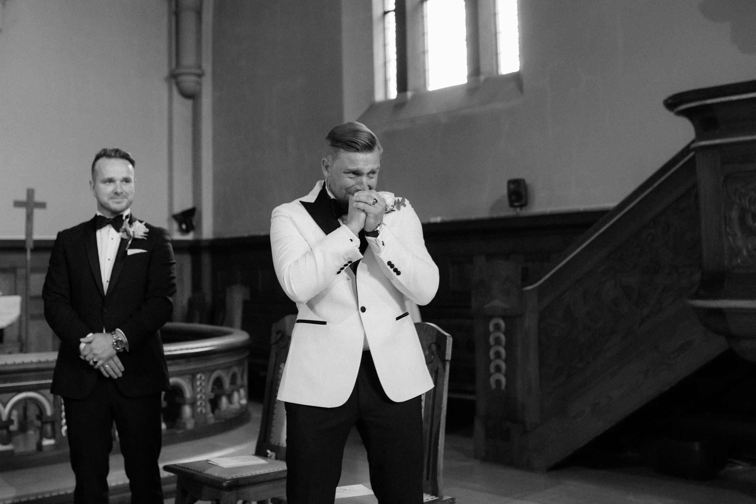 Black and white wedding ceremony photos show emotional reactions during special moments in church.