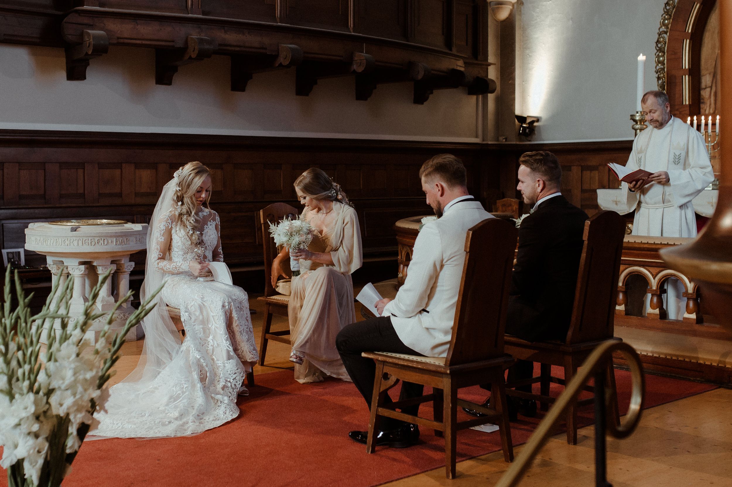 A tender moment during a wedding ceremony in a rustic church with wooden beams and traditional decor.