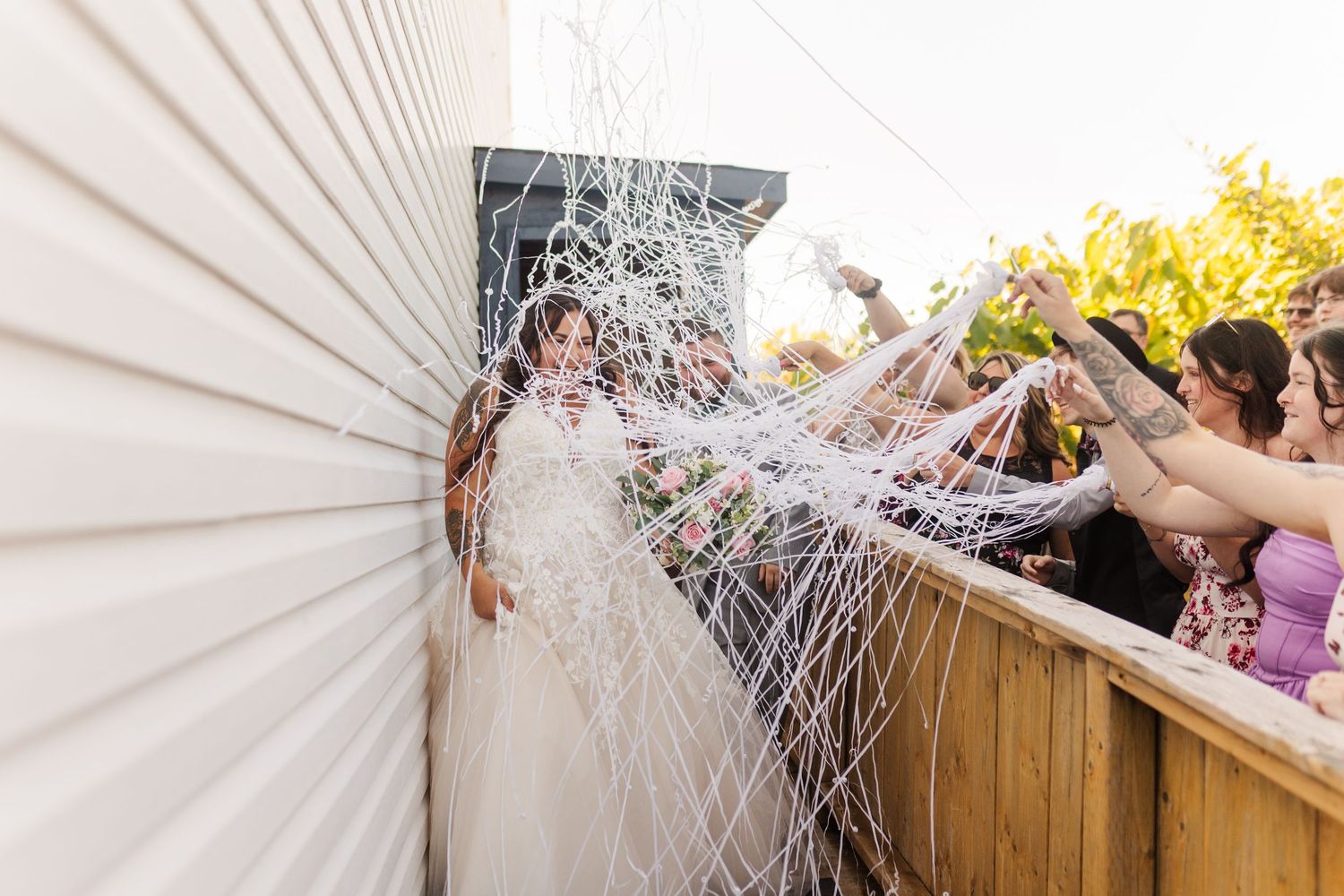 A sequence of guests at an outdoor event getting sprayed with white foam in an exciting party atmosphere.