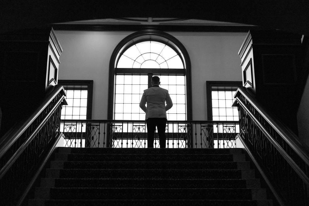 Black and white architectural photograph showing multiple balconies and windows creating strong geometric shadows.