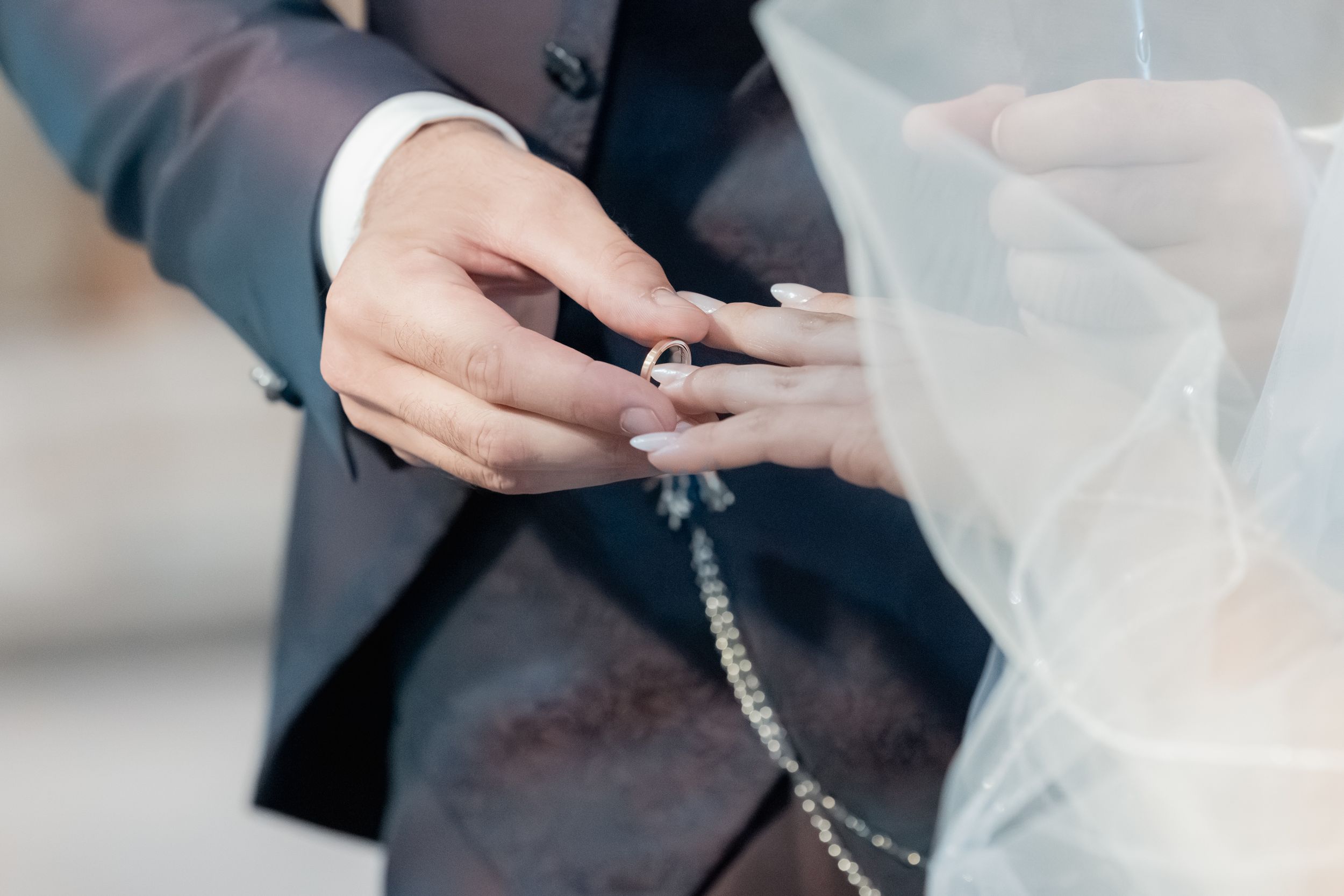 Two hands exchanging a car key against a blurred office background with documents on a table.