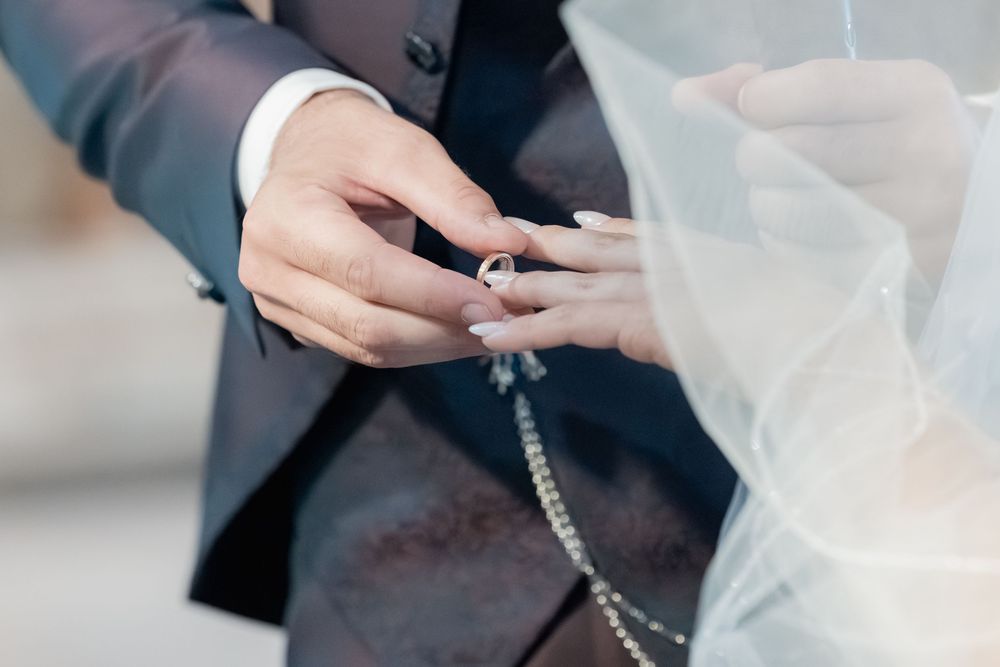 Two hands exchanging a car key against a blurred office background with documents on a table.