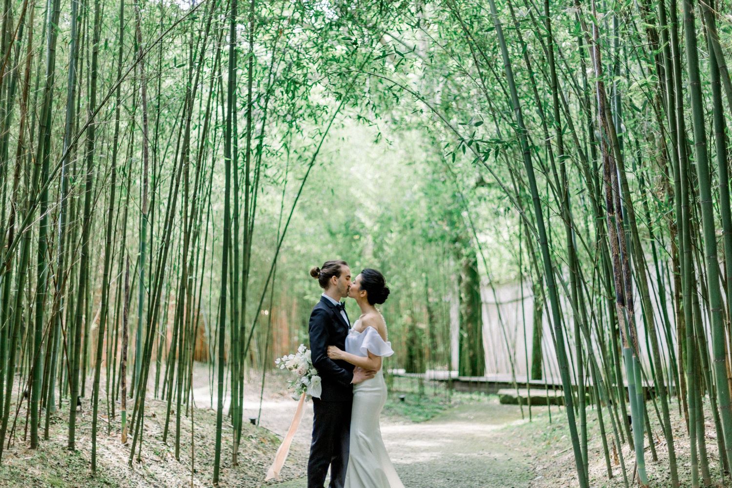 A romantic scene in a serene bamboo forest path with tall green stalks creating a natural archway.