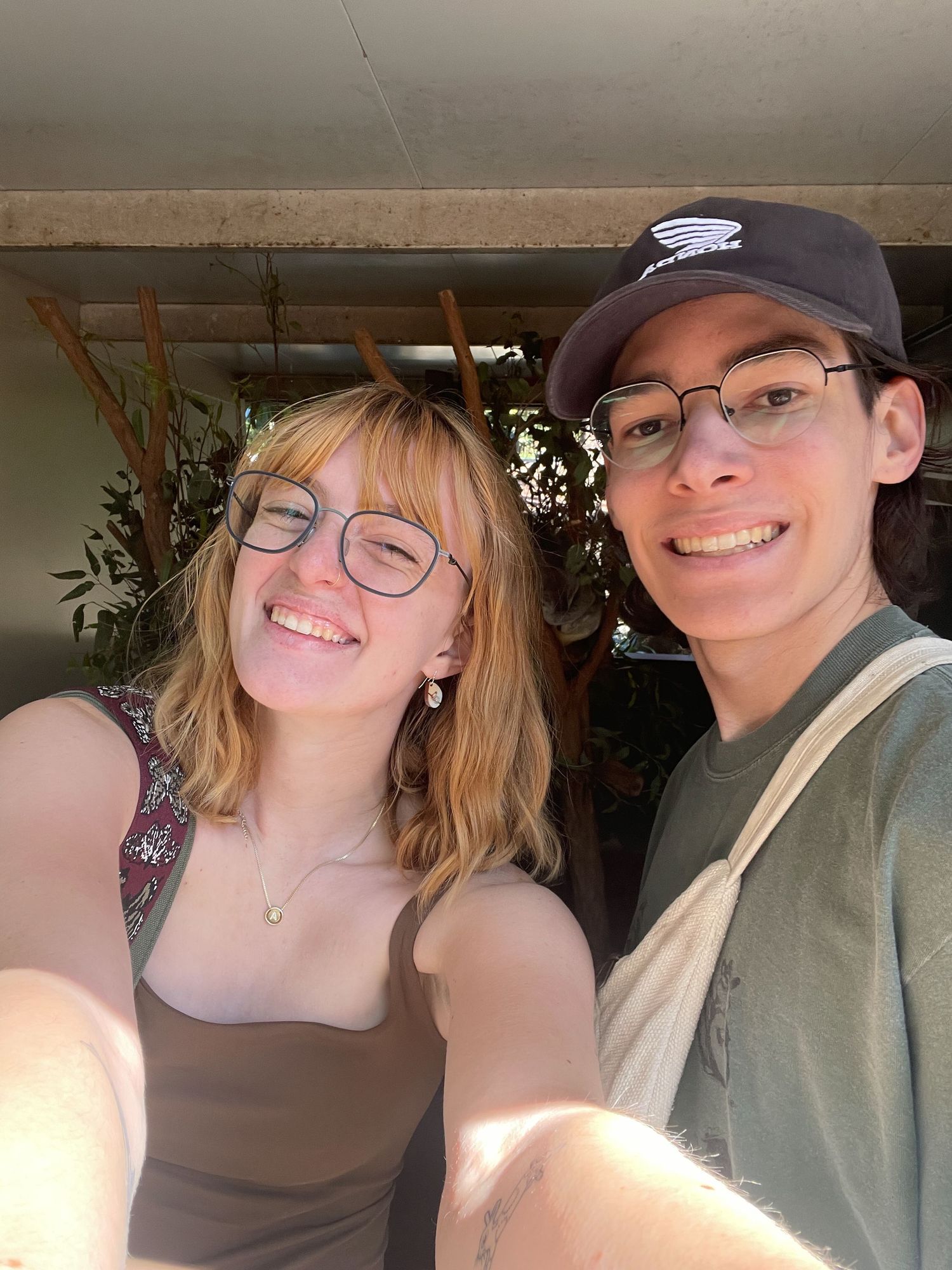 Two people wearing casual clothing pose together for five selfies in varying angles and lighting conditions.