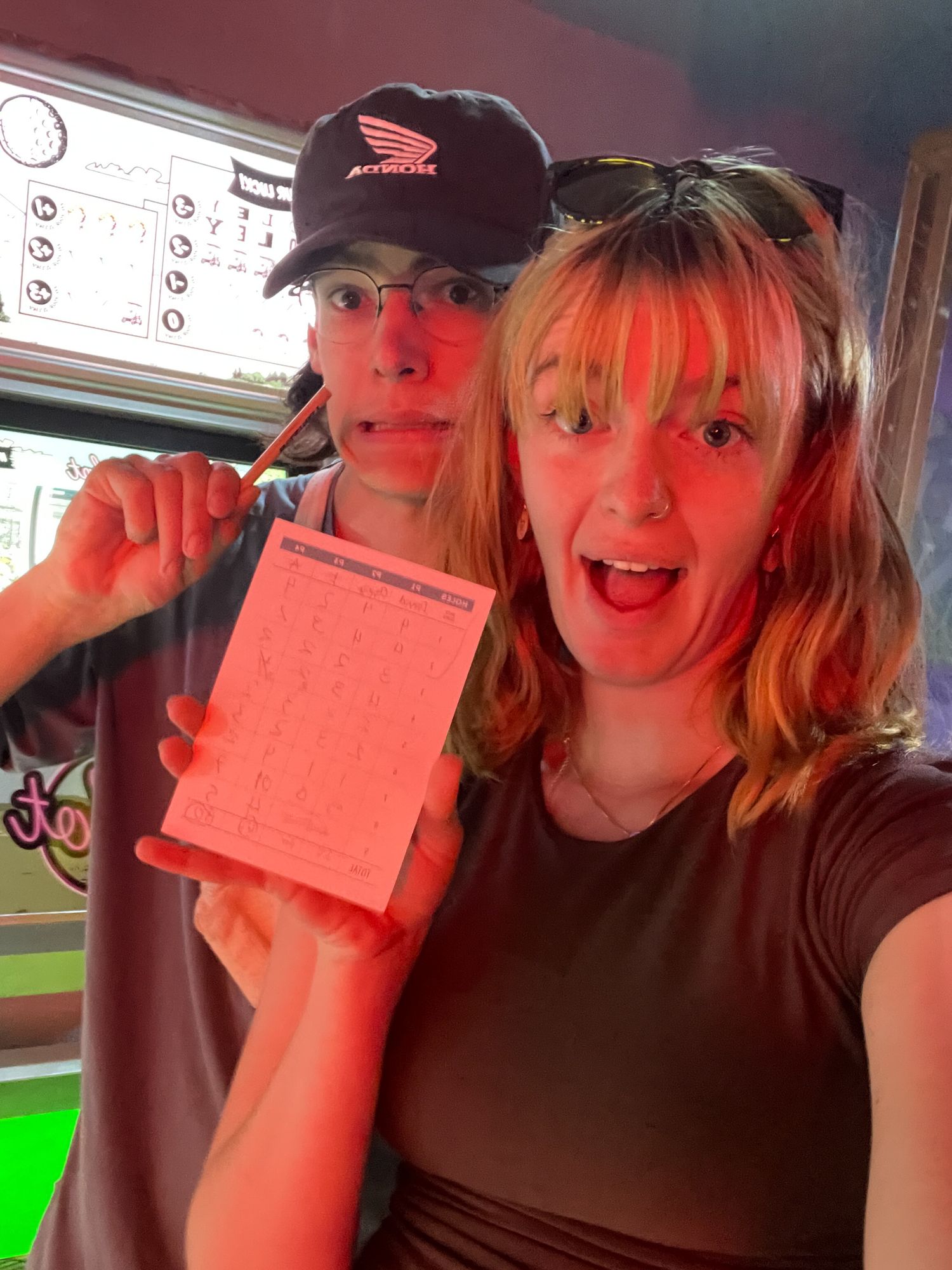 A series of four selfies showing someone holding up pink tickets in a car with excitement and enthusiasm.