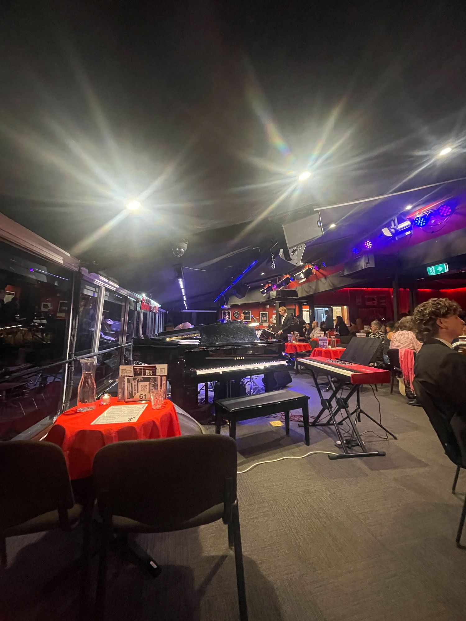 Dark interior view of a game room with pool tables and neon lighting creating a vibrant nightlife atmosphere.