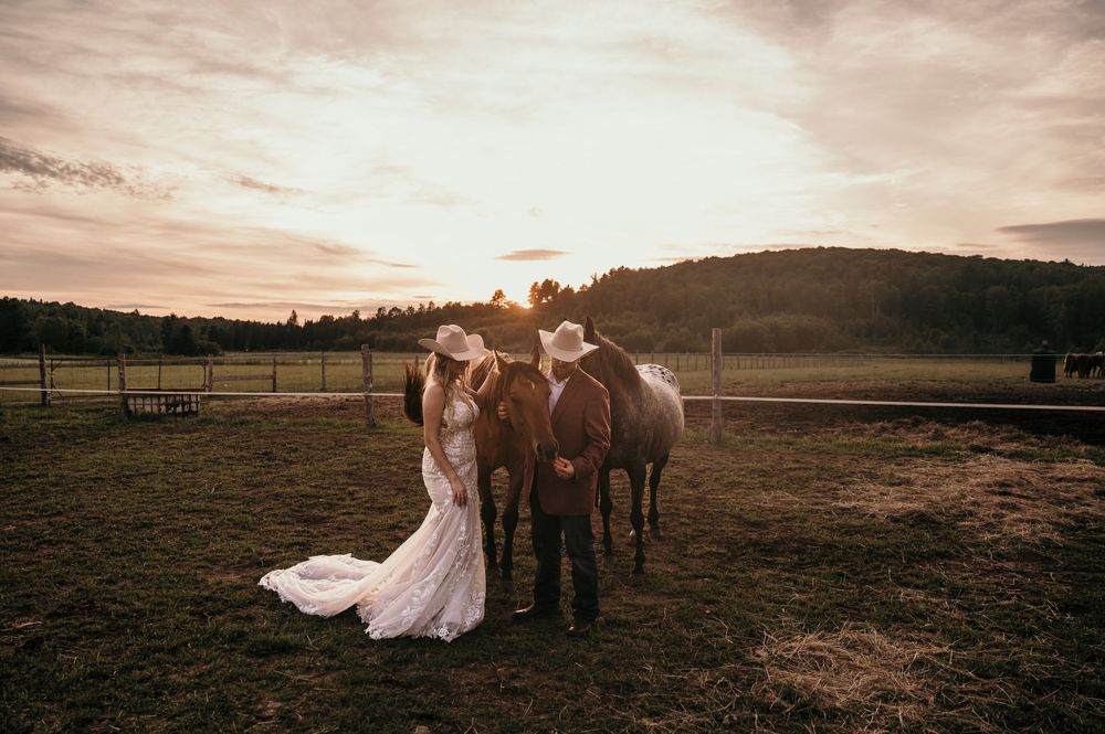 A romantic sunset engagement photo session in a rustic field with horses creates a dreamy golden hour atmosphere.