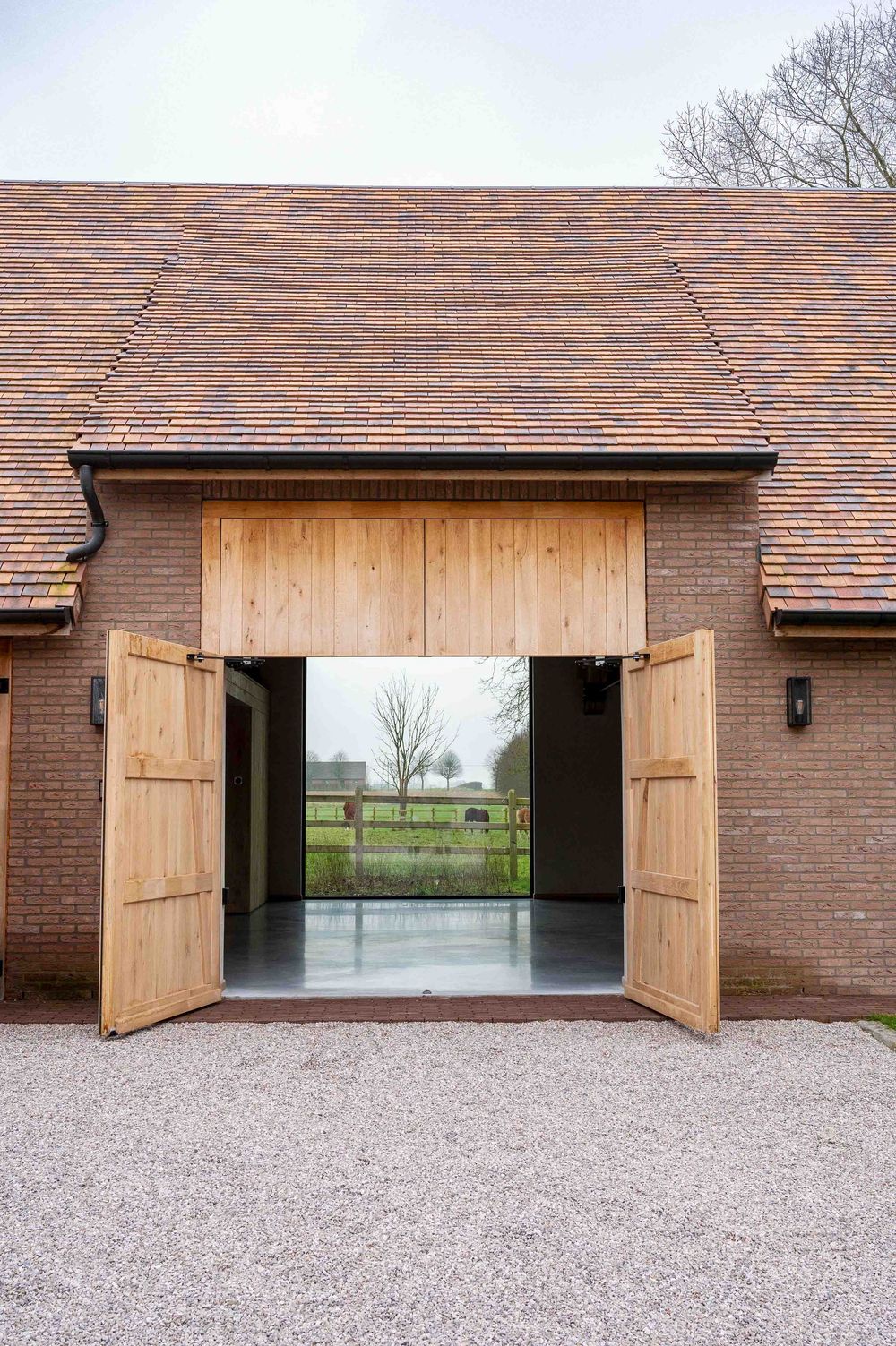 Brick building exterior with wooden shutters and gravel driveway.