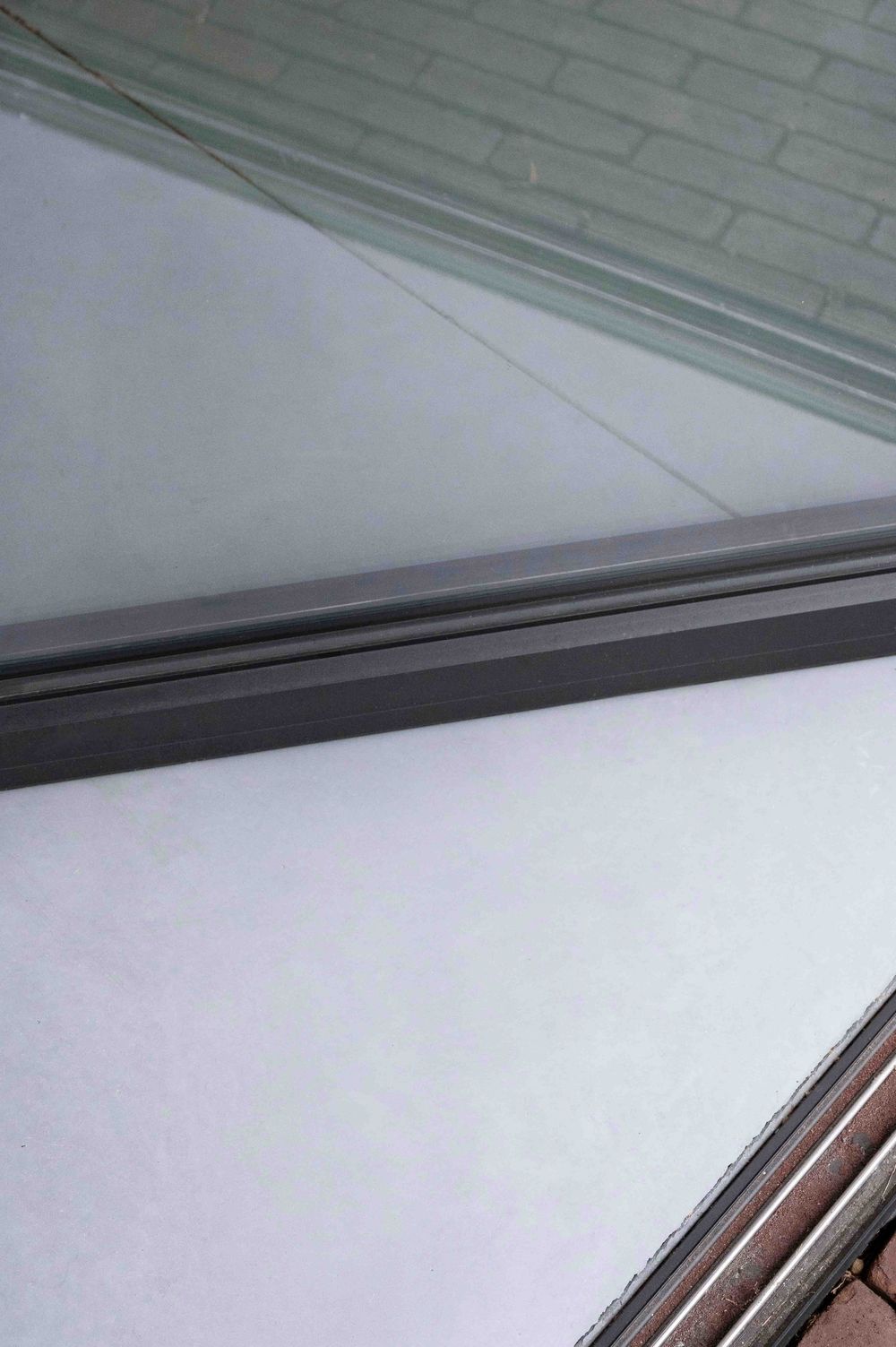 Close-up of modern window frame detail against white interior wall.