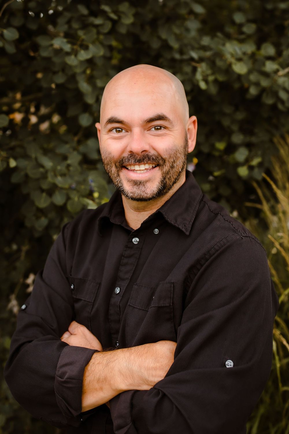 A business man smiles in his Denver Colorado outdoor headshot