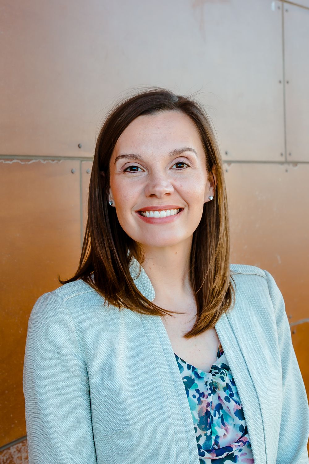 A professional woman smiles in her business headshot in Denver Colorado