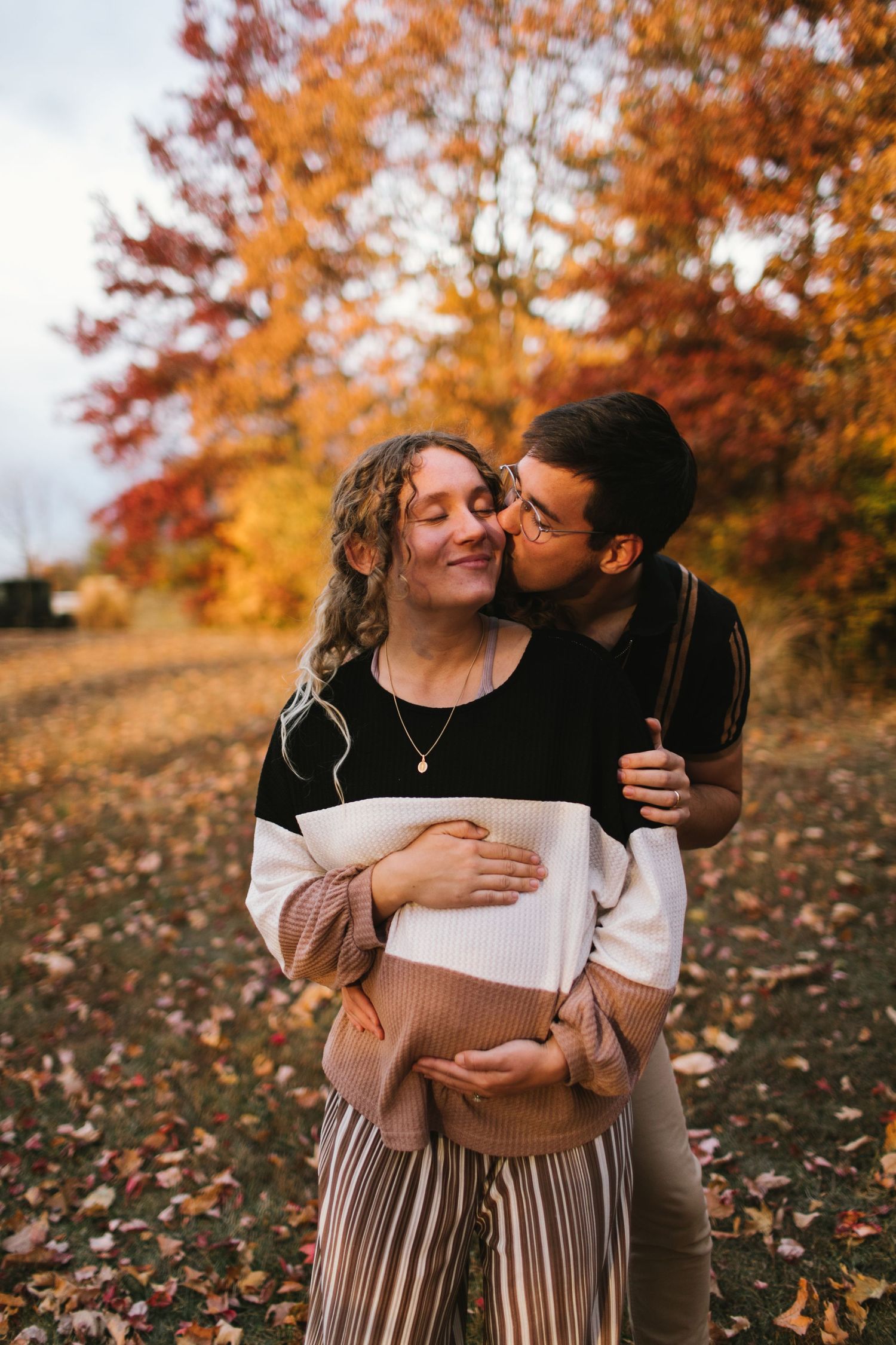 A romantic autumn scene with fall foliage and golden light in the background.