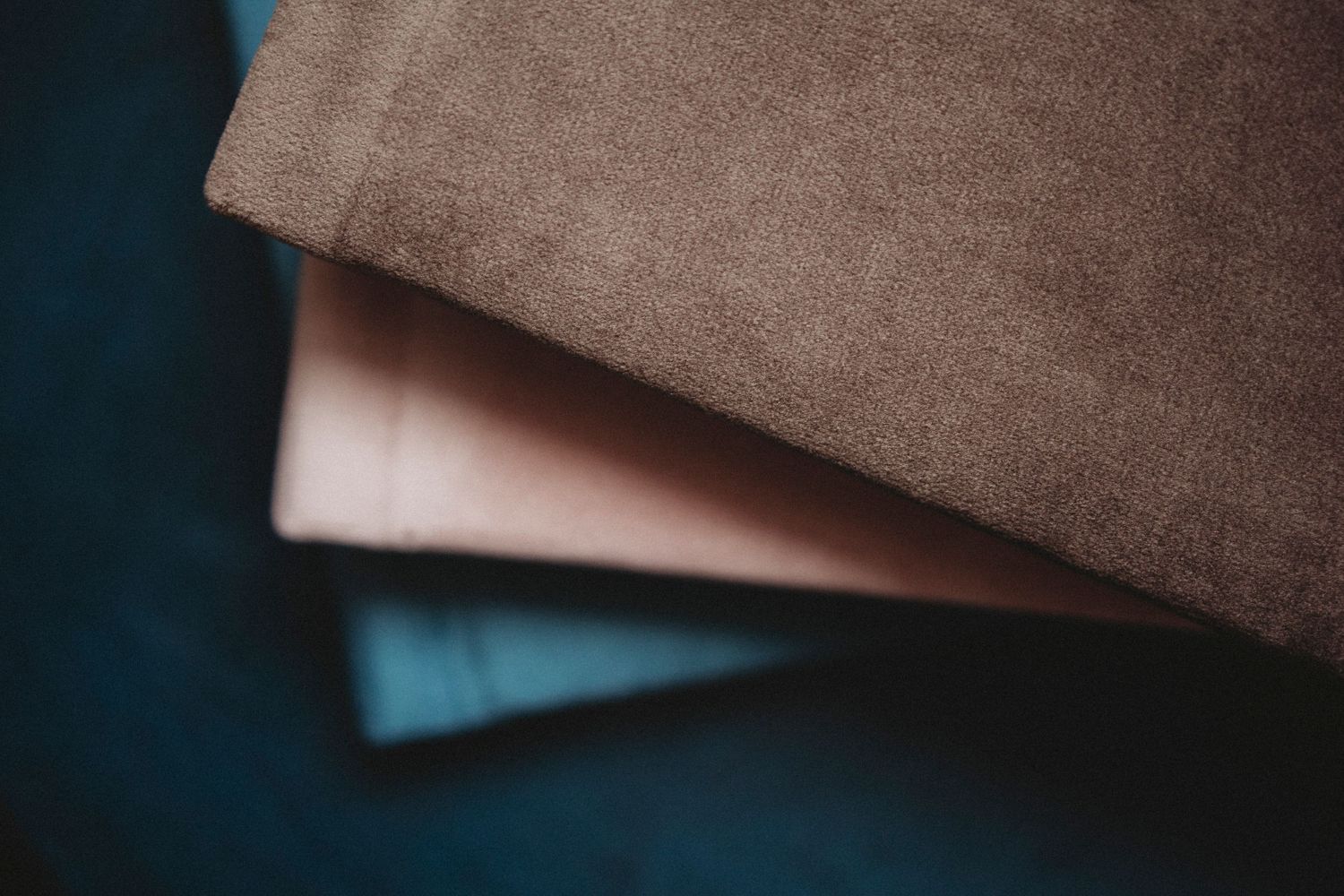 A close-up view of layered fabric materials in brown and beige tones with soft textural details.