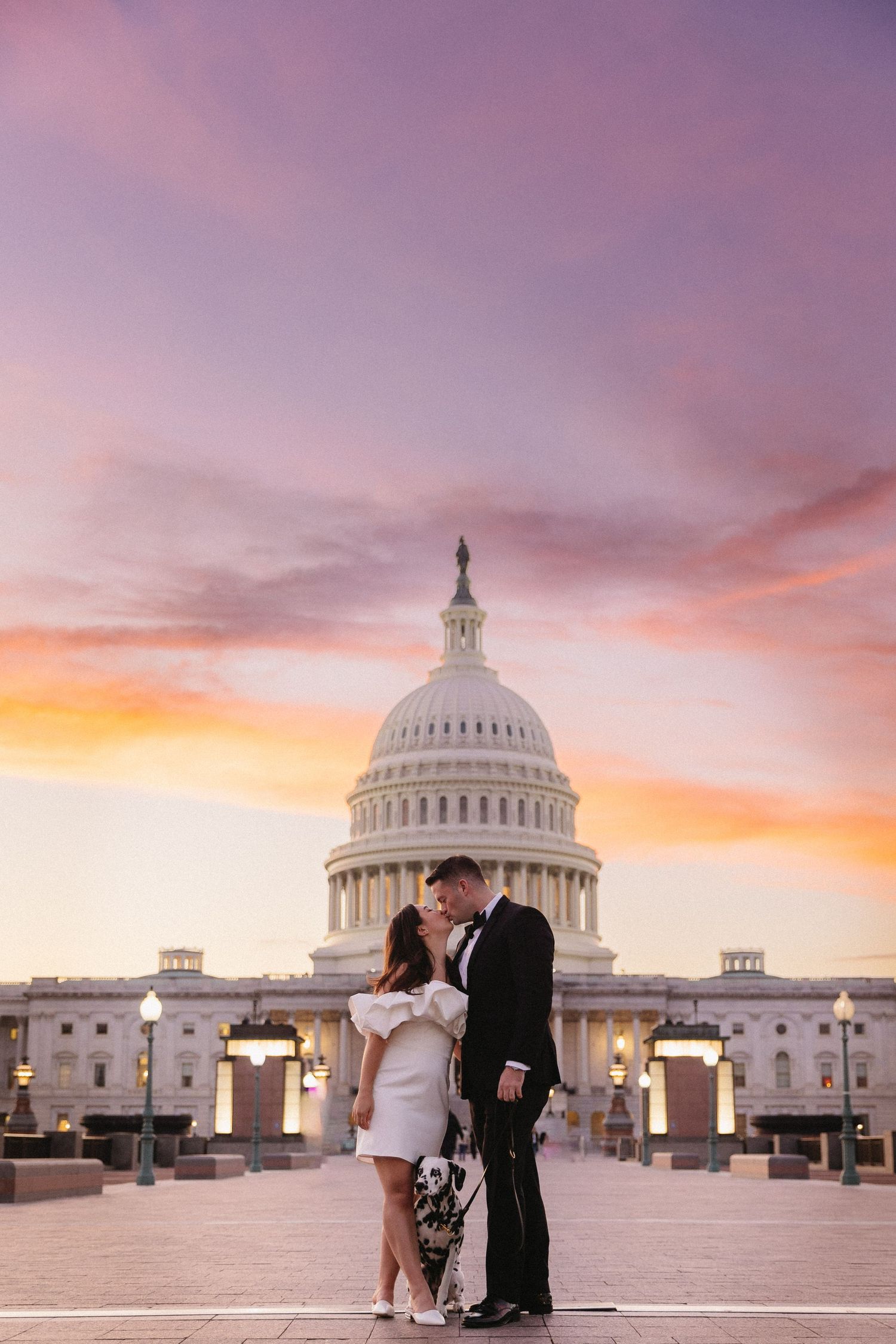A romantic couple shares an intimate moment in front of the U.S. Capitol building during a colorful sunset in Washington DC. Engagement.