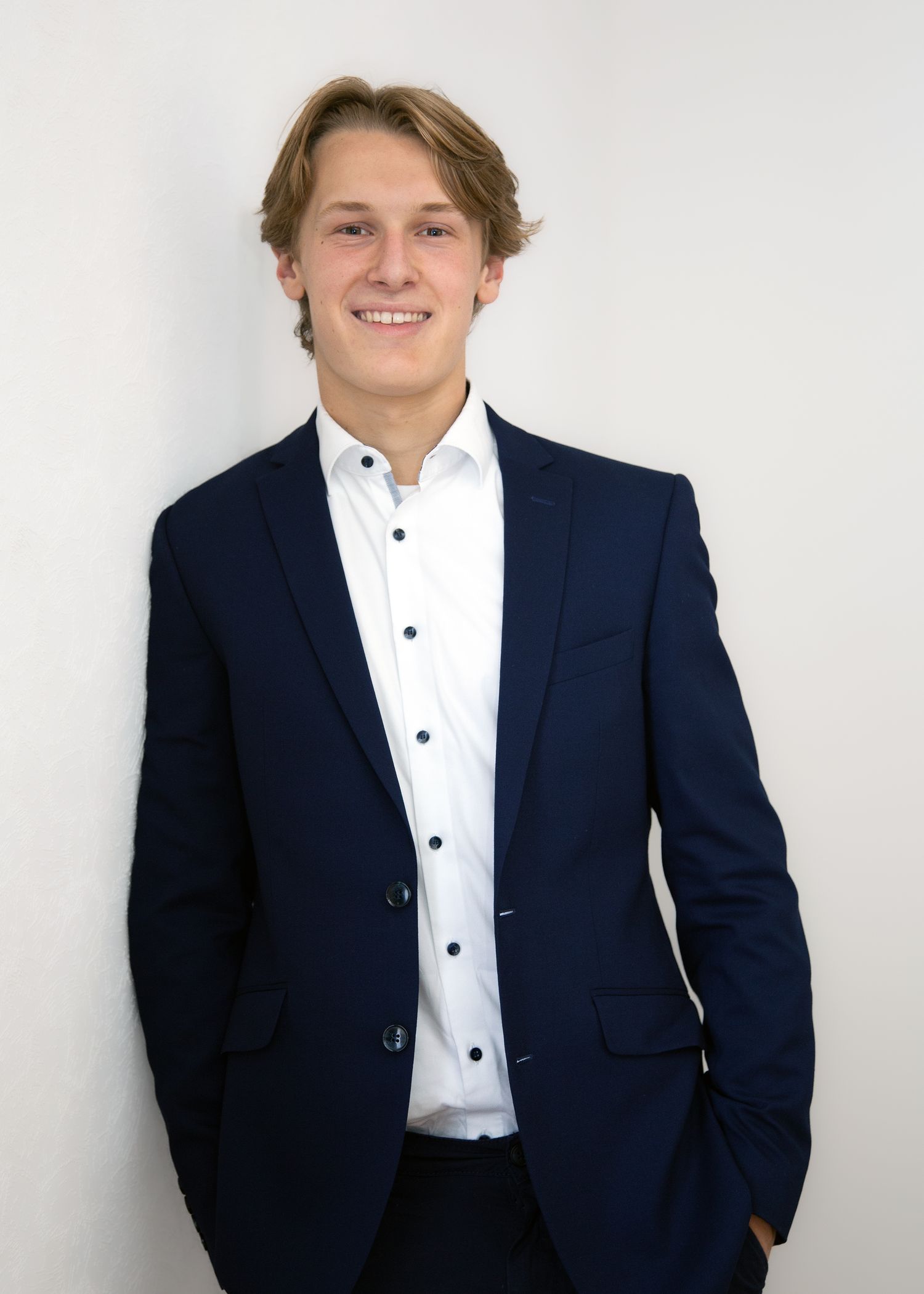 Modernes authentisches Bewerbungsfoto eines jungen Mannes mit Sakko und weißem Hemd in lässiger Pose im Studio Aurelia Schulz.