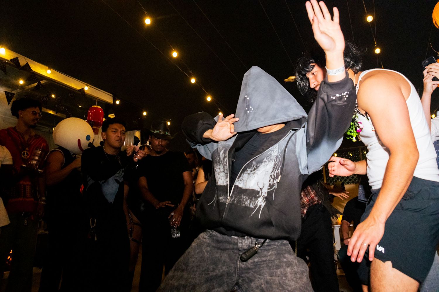 Dj Bingsoo dances in the crowd at Bittertones' nighttime costume party. An event photo taken at the Asian Garden Mall in Orange County.