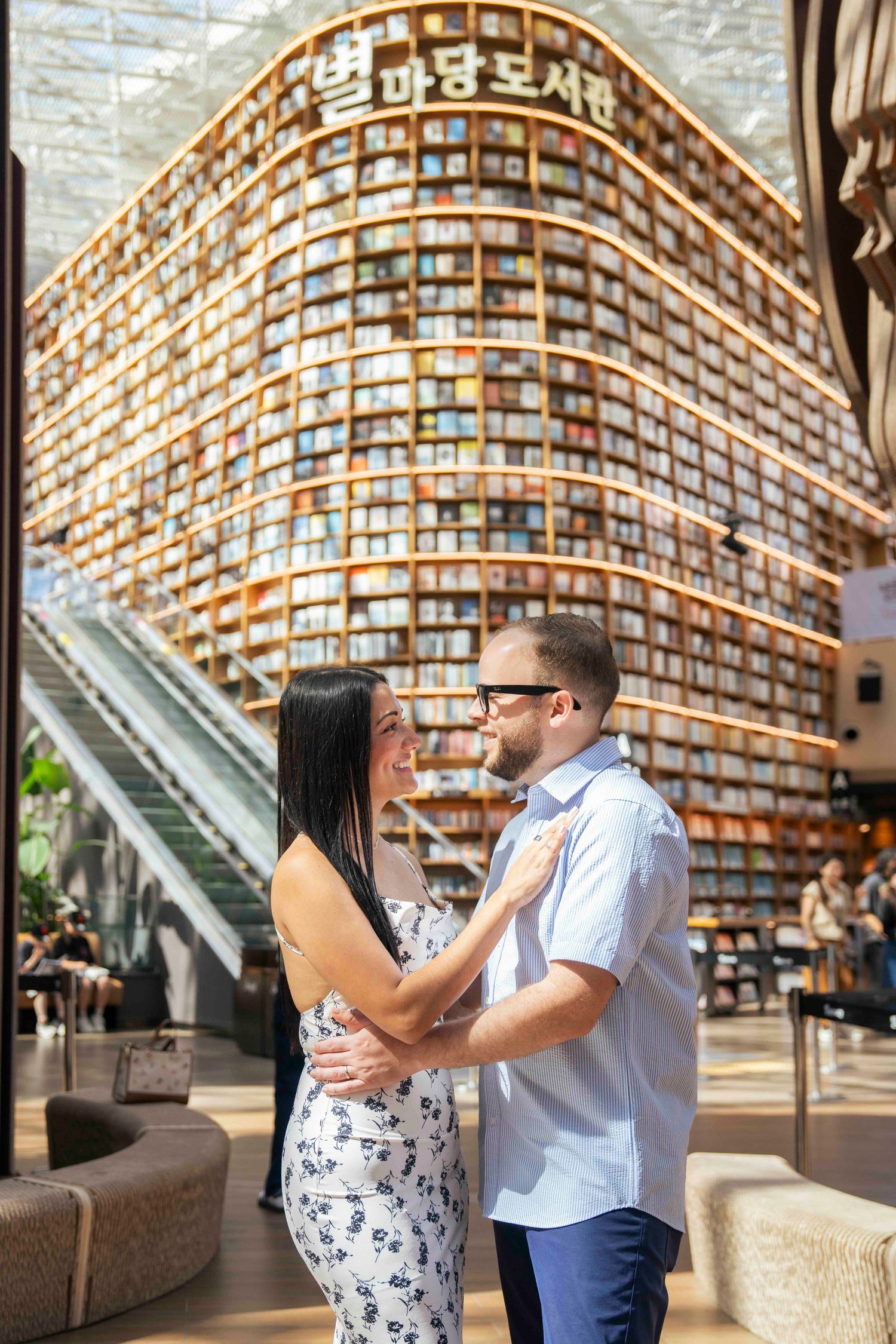 Couple embracing romantically in front of the stunning Starfield Library in COEX Mall, Seoul, South Korea.