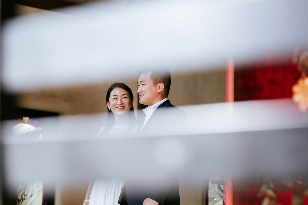 Bride and groom sharing a quiet laugh, framed through the chapel pews at their Fayetteville, Arkansas elopement
