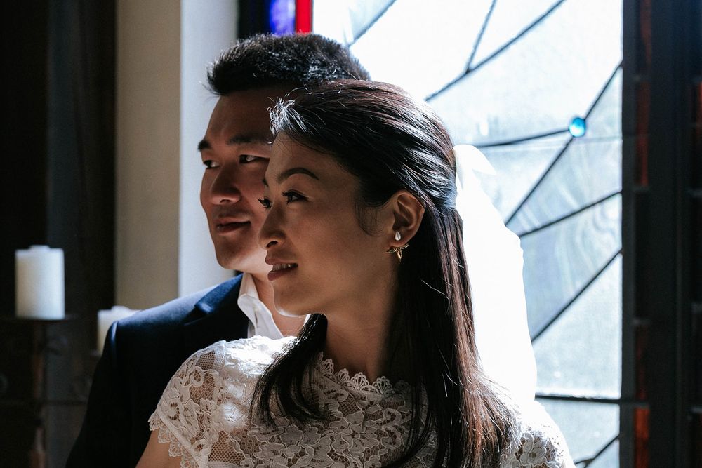 Bride and groom beside a stained-glass window during their Fayetteville, Arkansas chapel elopement