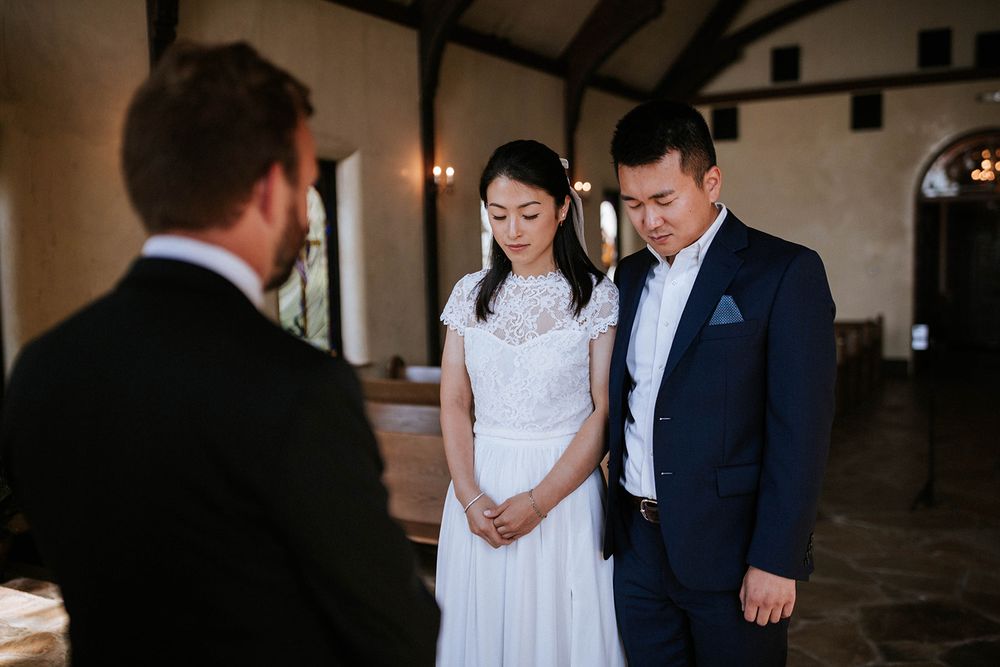 Bride and groom facing their officiant at the start of an intimate chapel elopement in Fayetteville, Arkansas